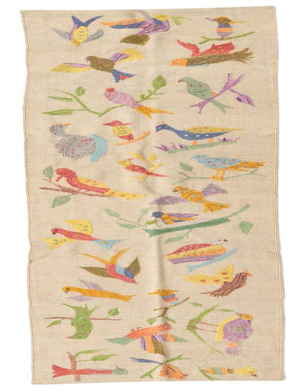 A 9 ft Kilim Suzani runner rug with a cream background and colorful embroidered birds and branches.