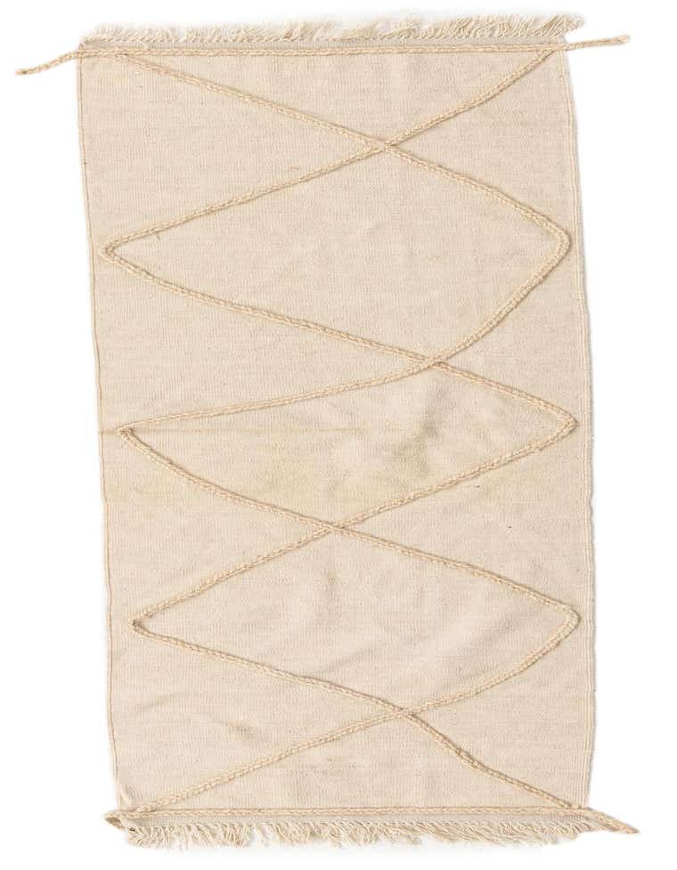 An 8 ft runner rug in ivory wool with a cream tribal diamond pattern, featuring shag pile and fringe.