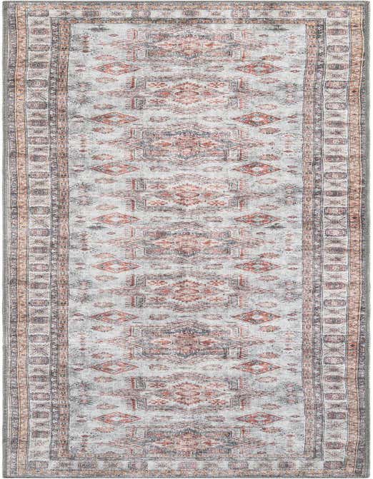 A 10 ft runner rug in shades of ivory and cream with a distressed traditional pattern in rust, grey, and orange.