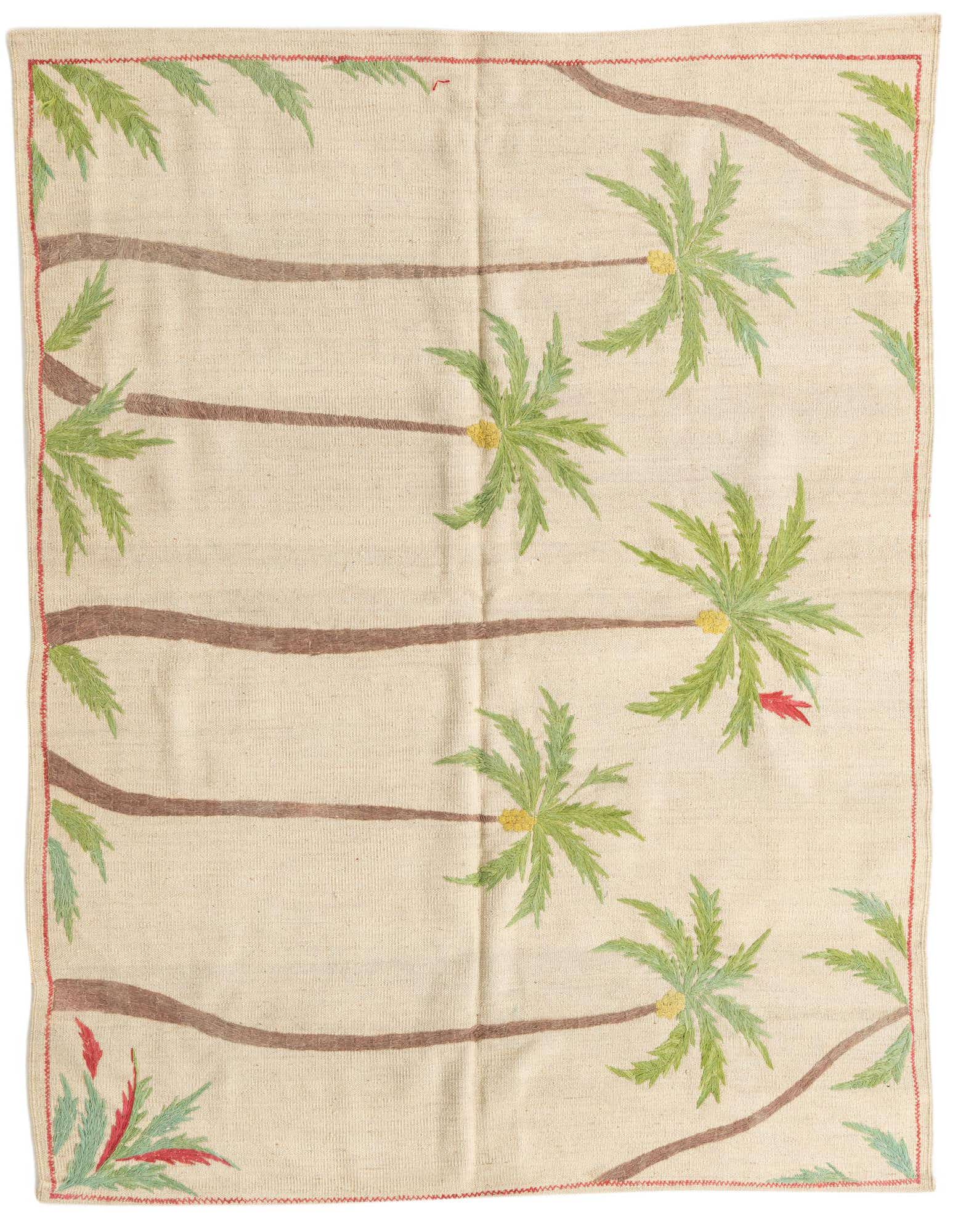 A square ivory flatweave rug with a tribal palm tree pattern, featuring green fronds, brown trunks, and red accents.
