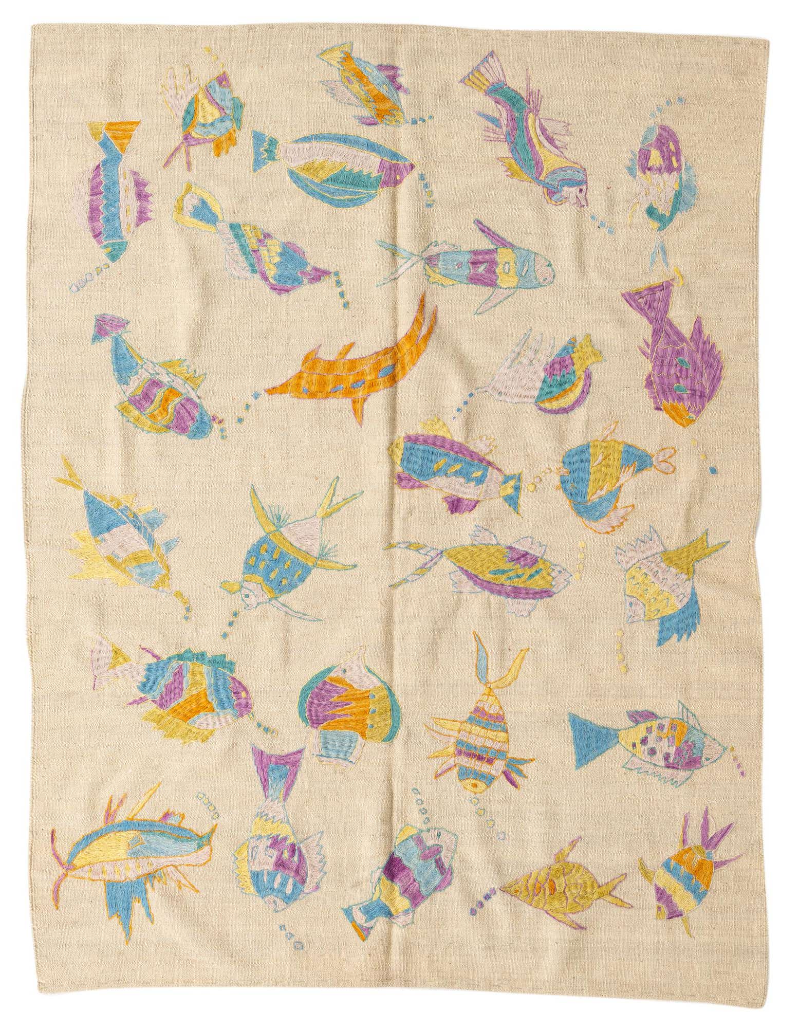 A square ivory flatweave rug with colorful embroidered fish in blue, purple, yellow, and orange, arranged in a playful tribal pattern.