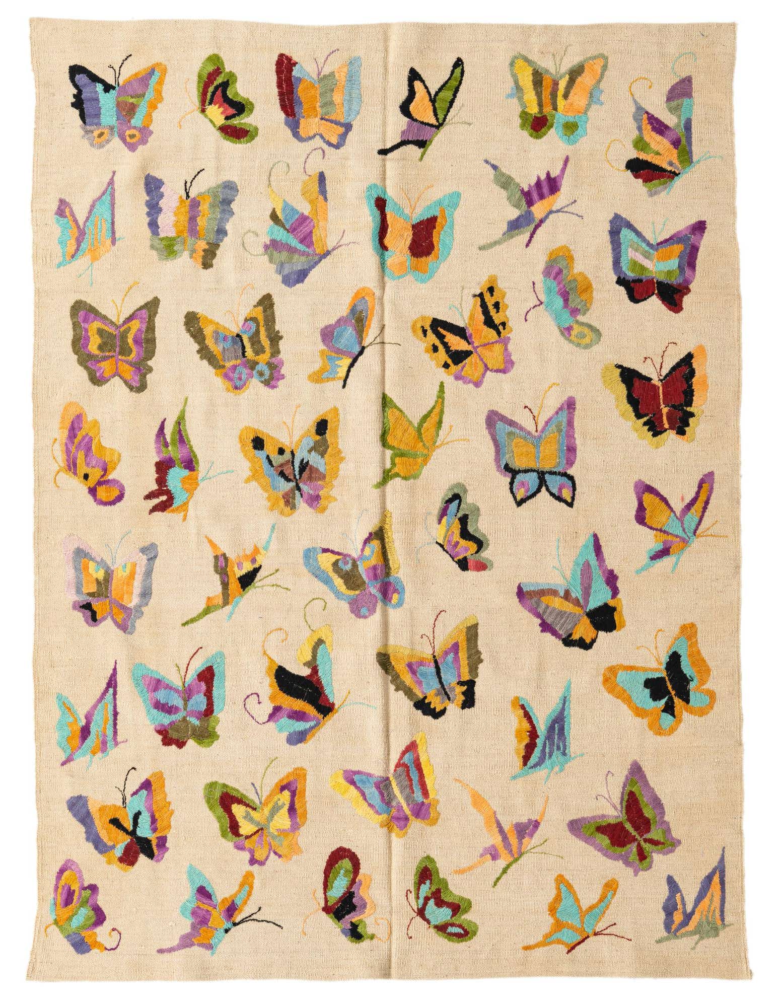 A cream-colored flatweave wool rug featuring a vibrant, scattered pattern of colorful butterflies in various sizes and orientations.
