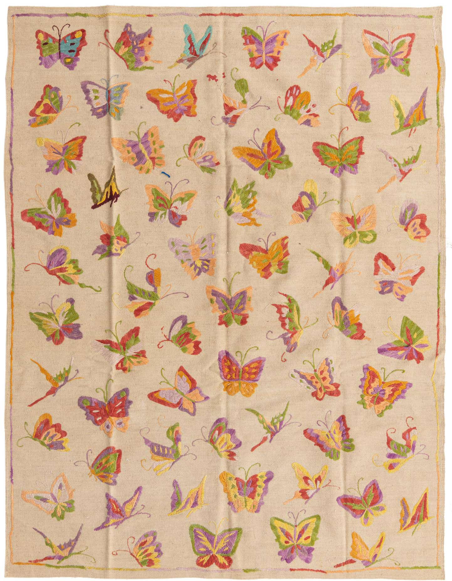 A 5x8 rectangular ivory flatweave rug featuring a vibrant, multicolored butterfly pattern, suitable for a living room.