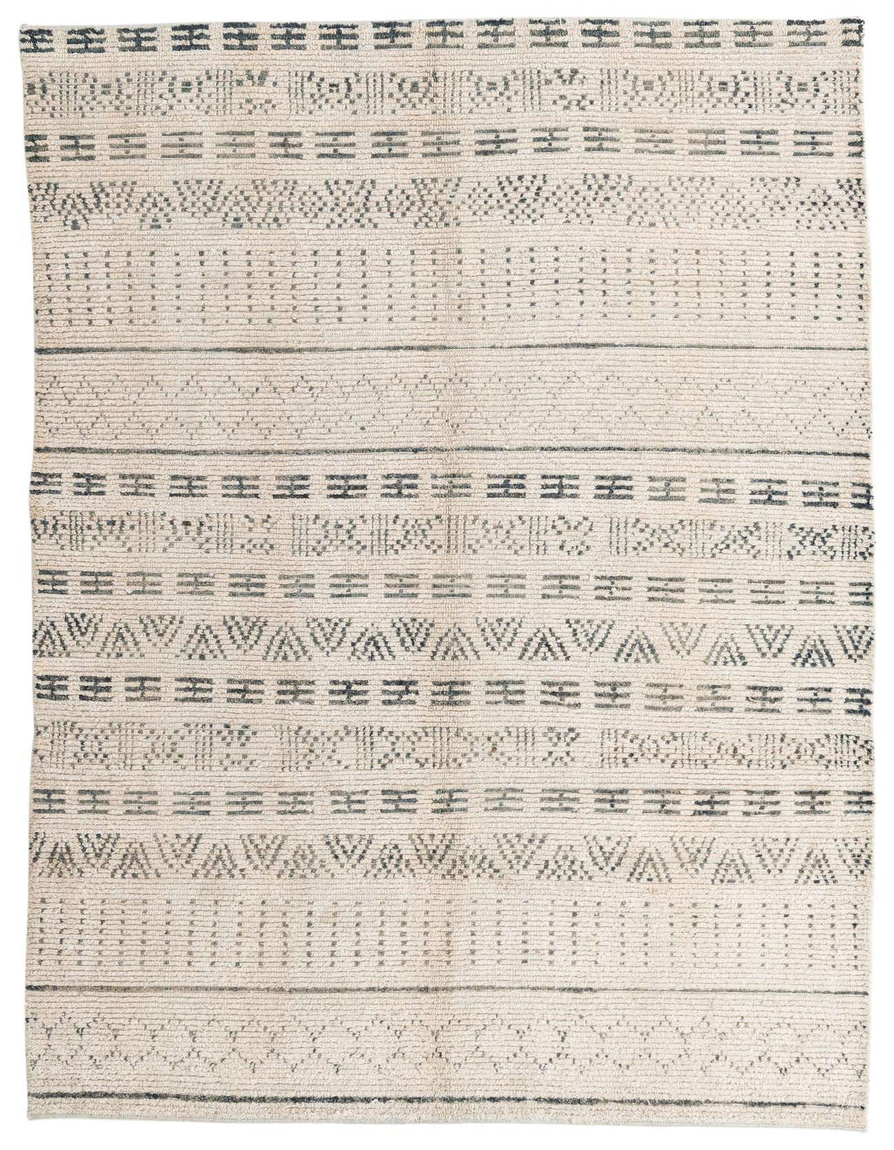 A 6x9 rectangular ivory wool shag rug with horizontal bands of dark grey tribal and geometric patterns.