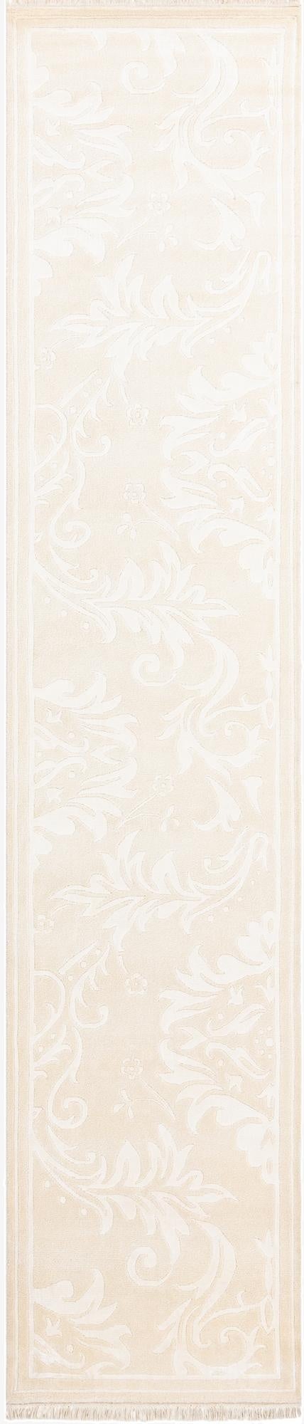 A 13 ft ivory wool runner rug with a subtle raised modern oriental pattern and fringed ends, ideal for a hallway.