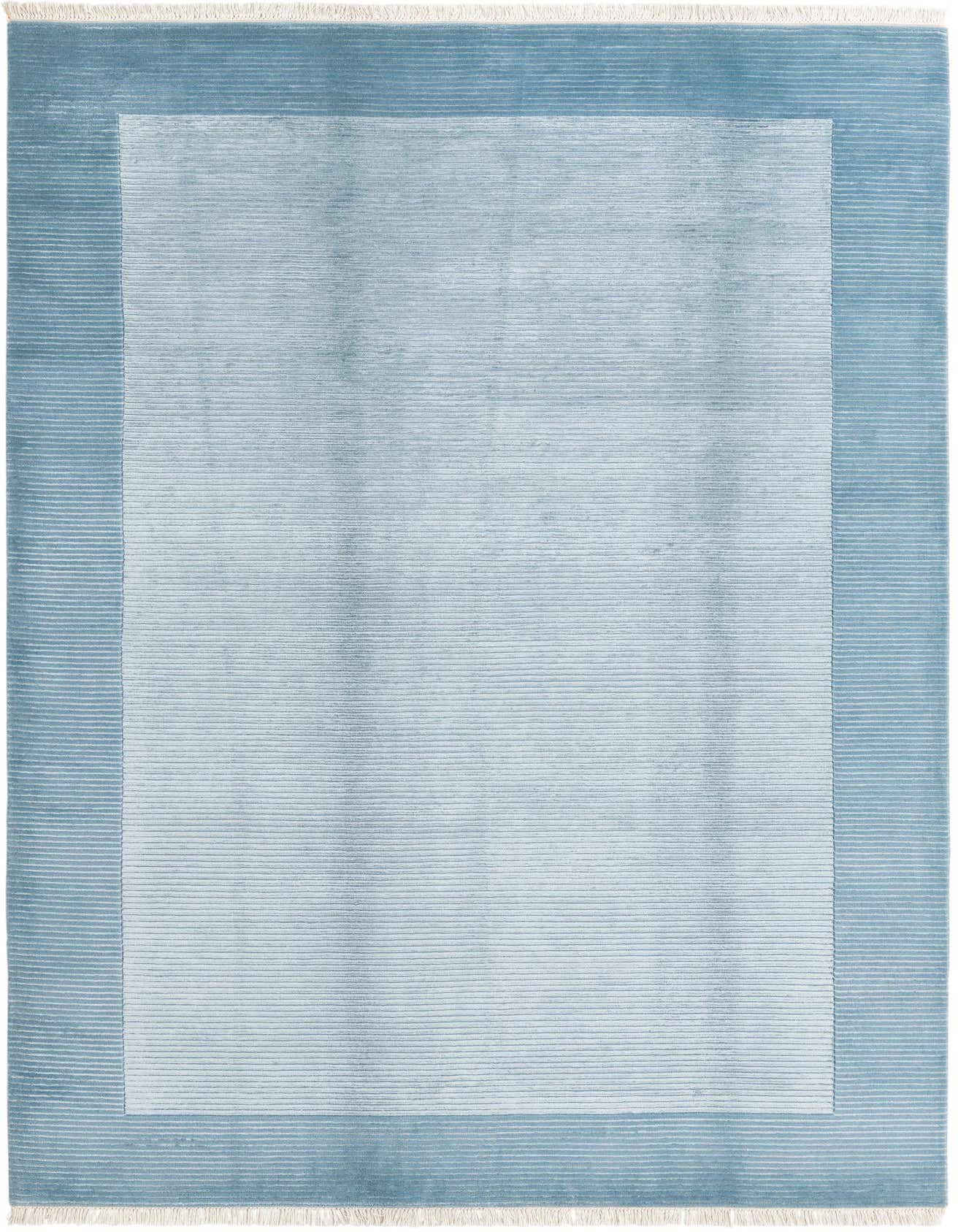 A 7x10 rectangular Darya rug in varying shades of blue, featuring a lighter blue center with horizontal lines and a darker blue border with similar texture, finished with white fringe.