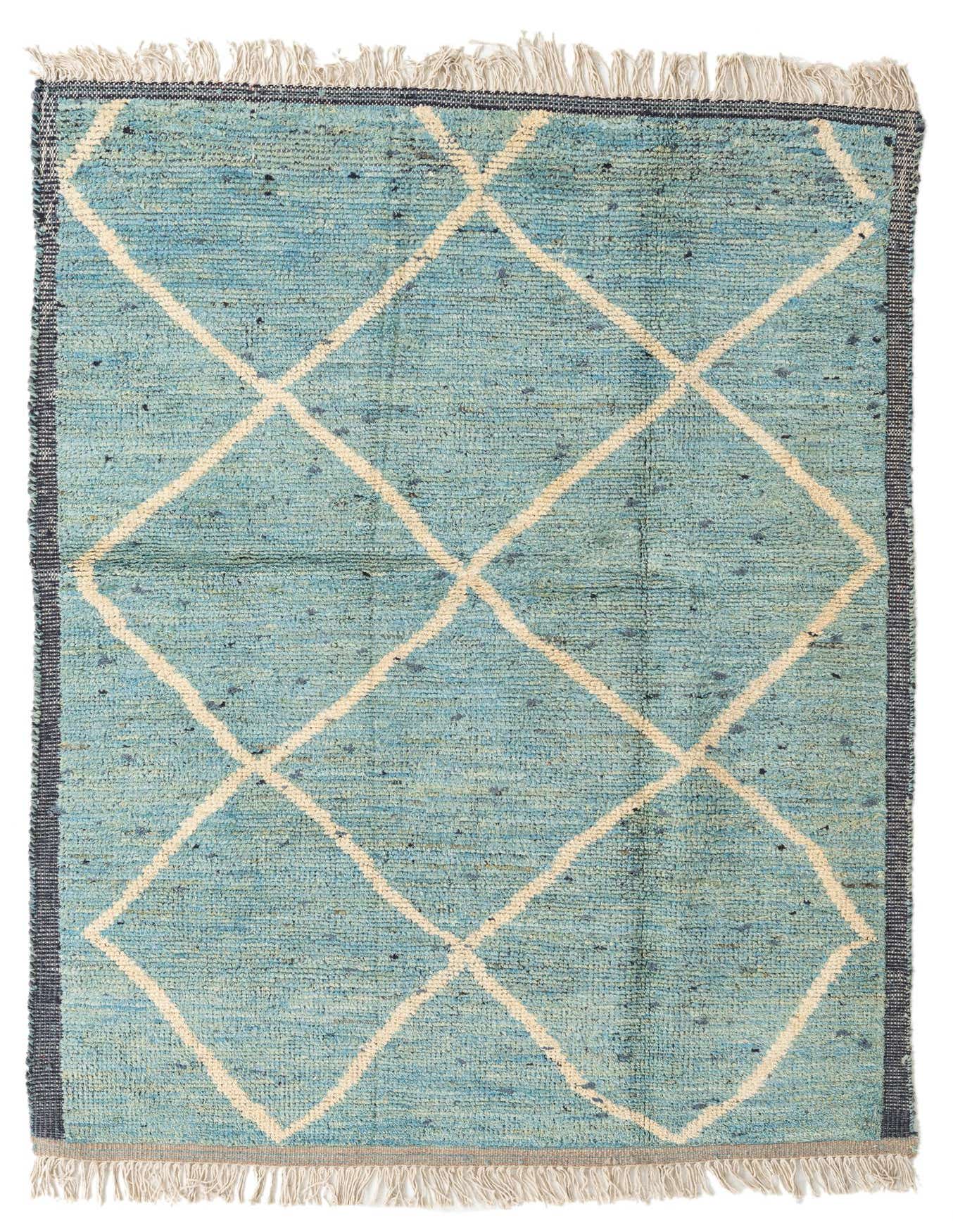 A 5x8 rectangular light blue shag rug with a cream diamond tribal pattern and fringed ends, suitable for a living room.
