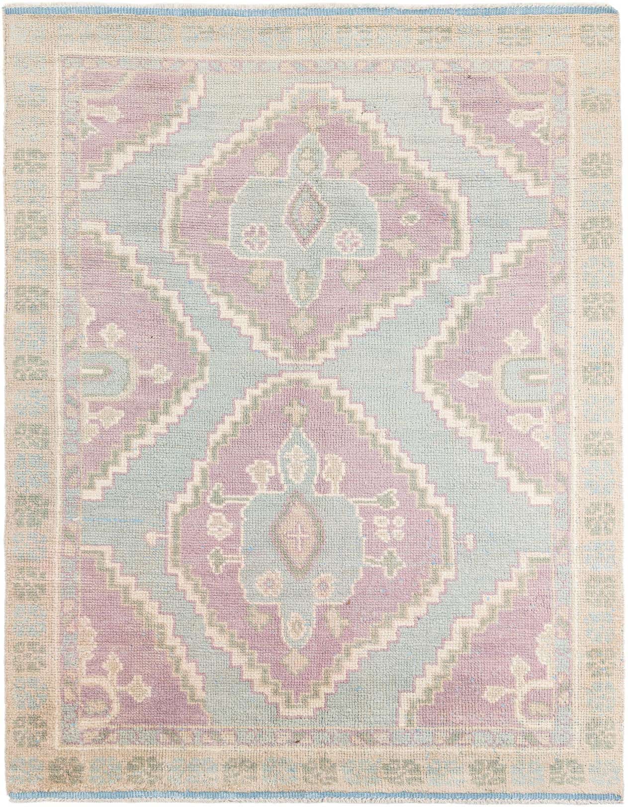 A 6x9 rectangular shag rug with a tribal medallion pattern in light blue, lavender, and cream tones, perfect for a living room.