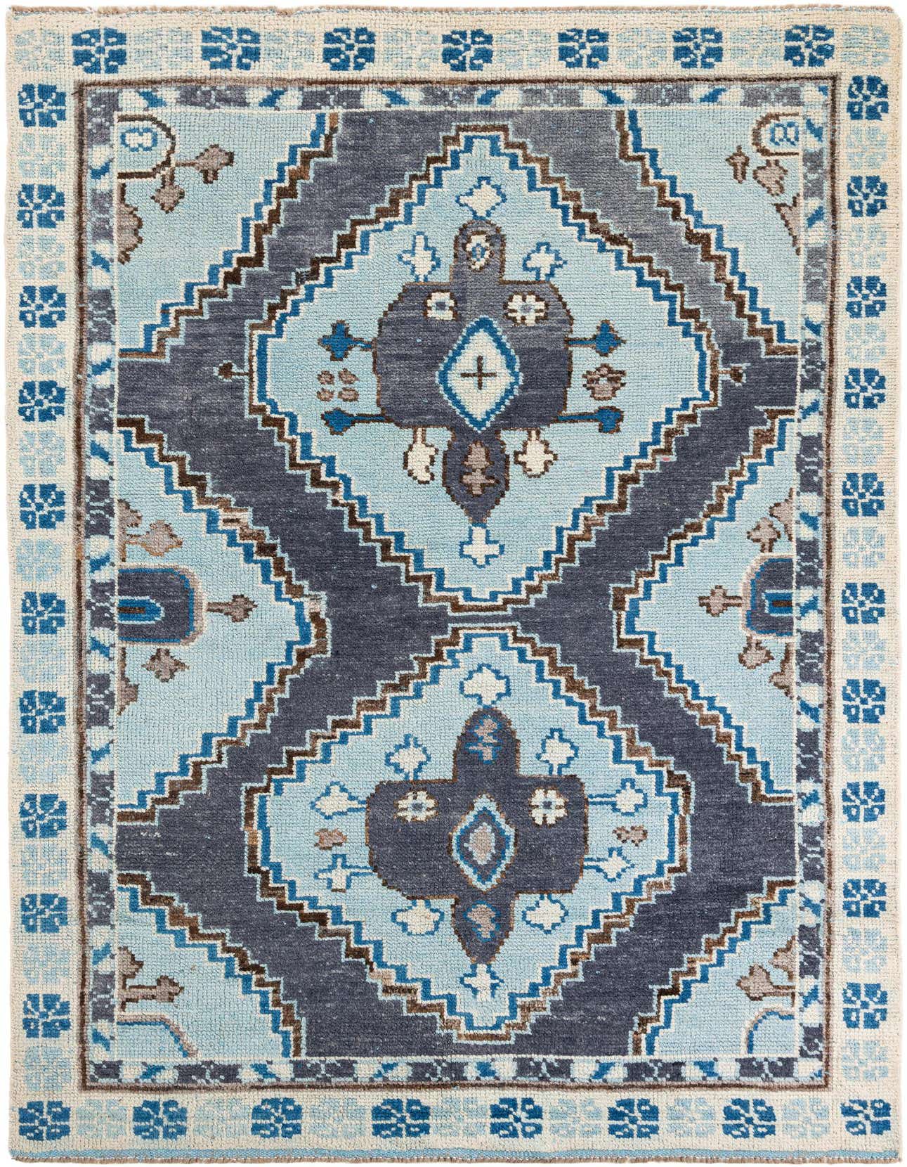 A 6x9 rectangular light blue and navy blue Moroccan tribal wool rug with a central medallion and shag pile.