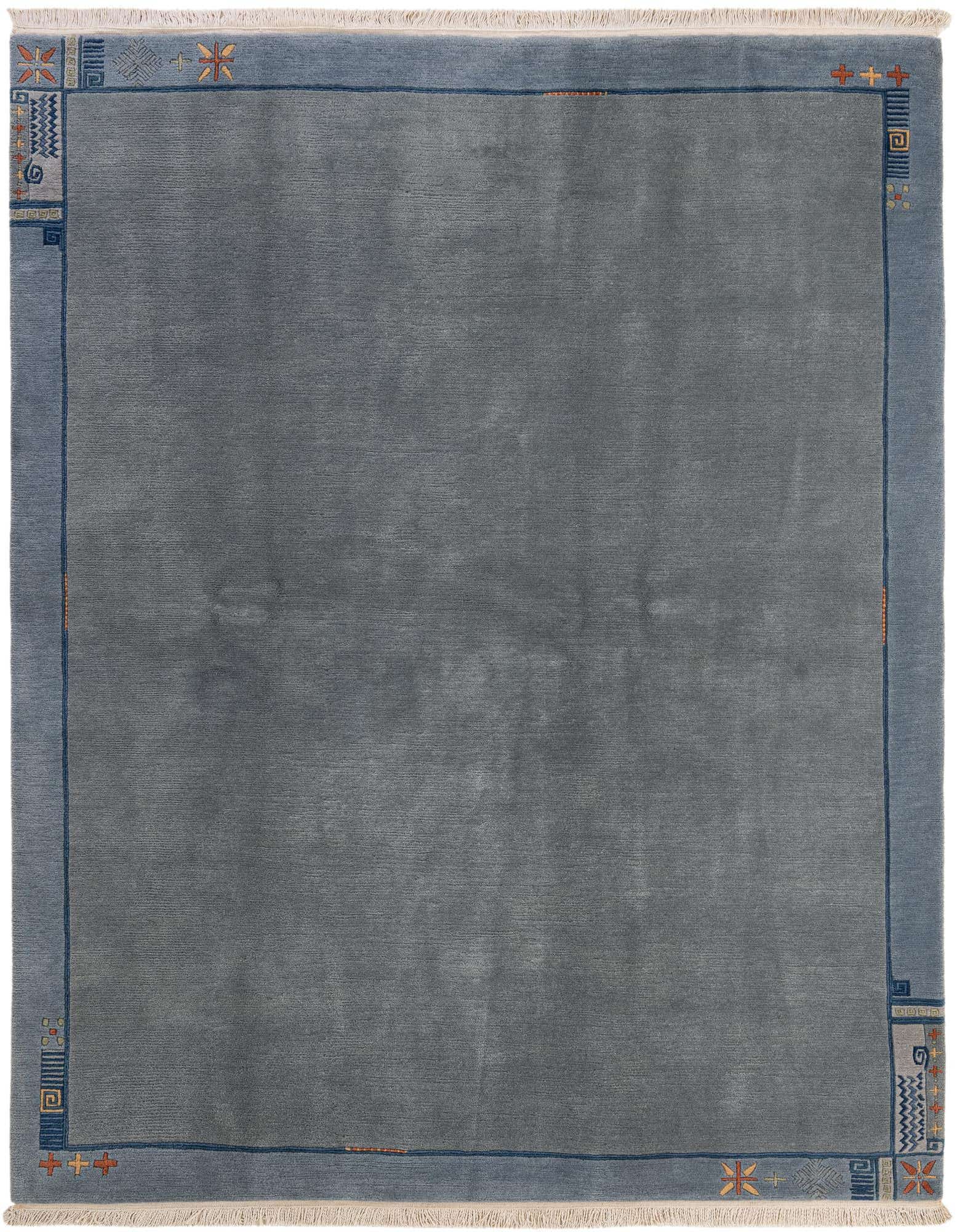 A 6x9 rectangular Tibet Collection wool rug in varying shades of blue, featuring a solid center and a border with abstract and geometric patterns.