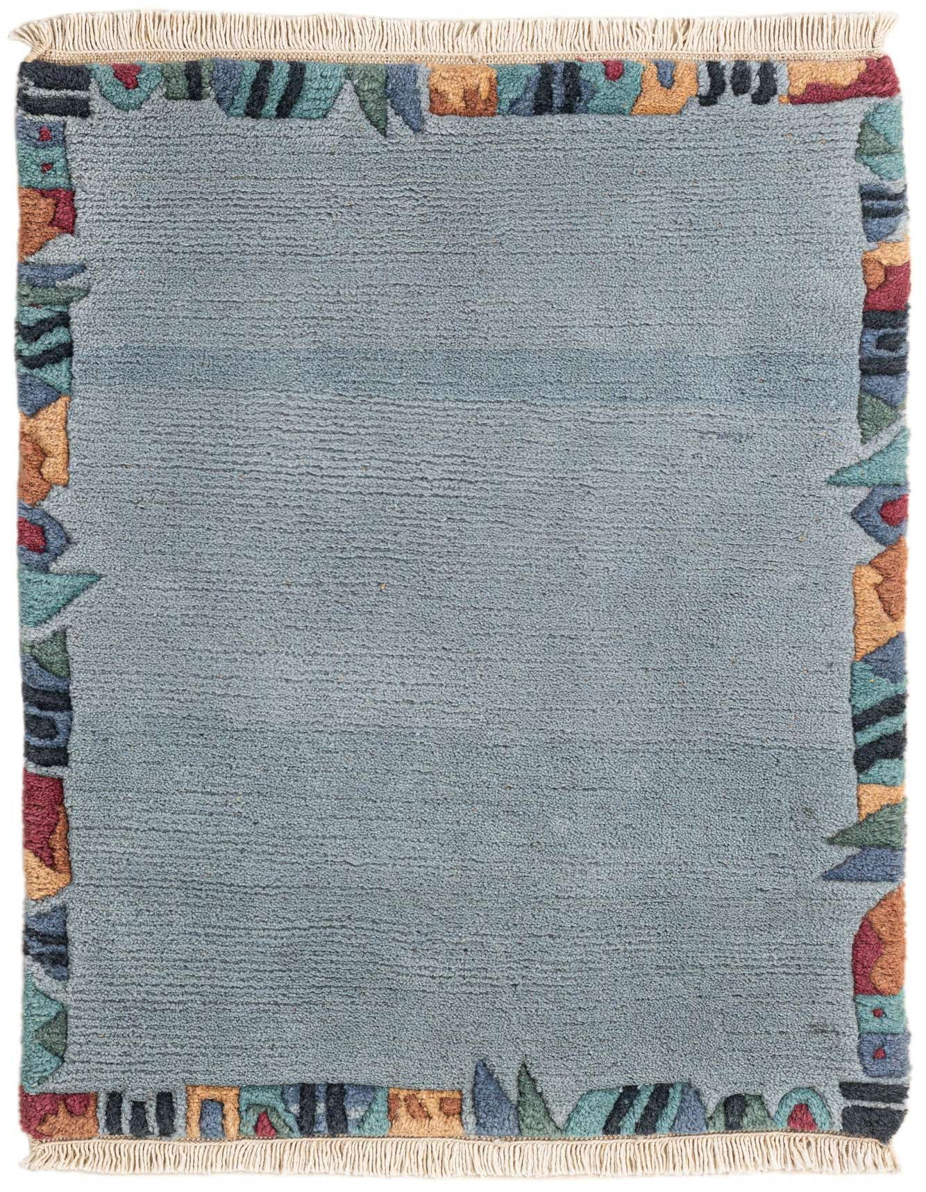 A 2x3 rectangular light blue wool rug with a colorful abstract border and fringe, ideal for an entryway.