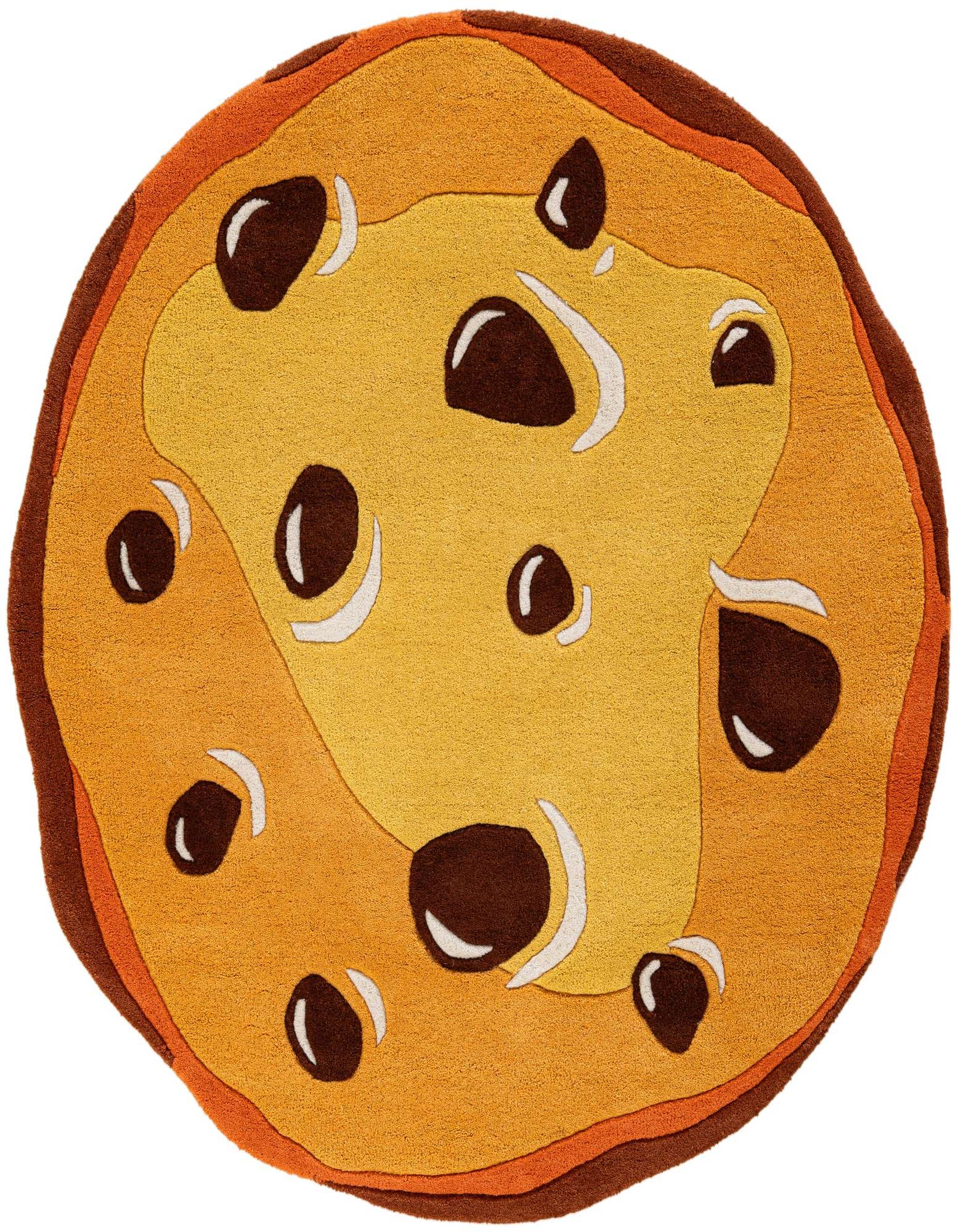 A round, freeform rug designed to look like a chocolate chip cookie, featuring shades of tan and brown with dark brown 'chocolate chips' and white accents, on a white background.