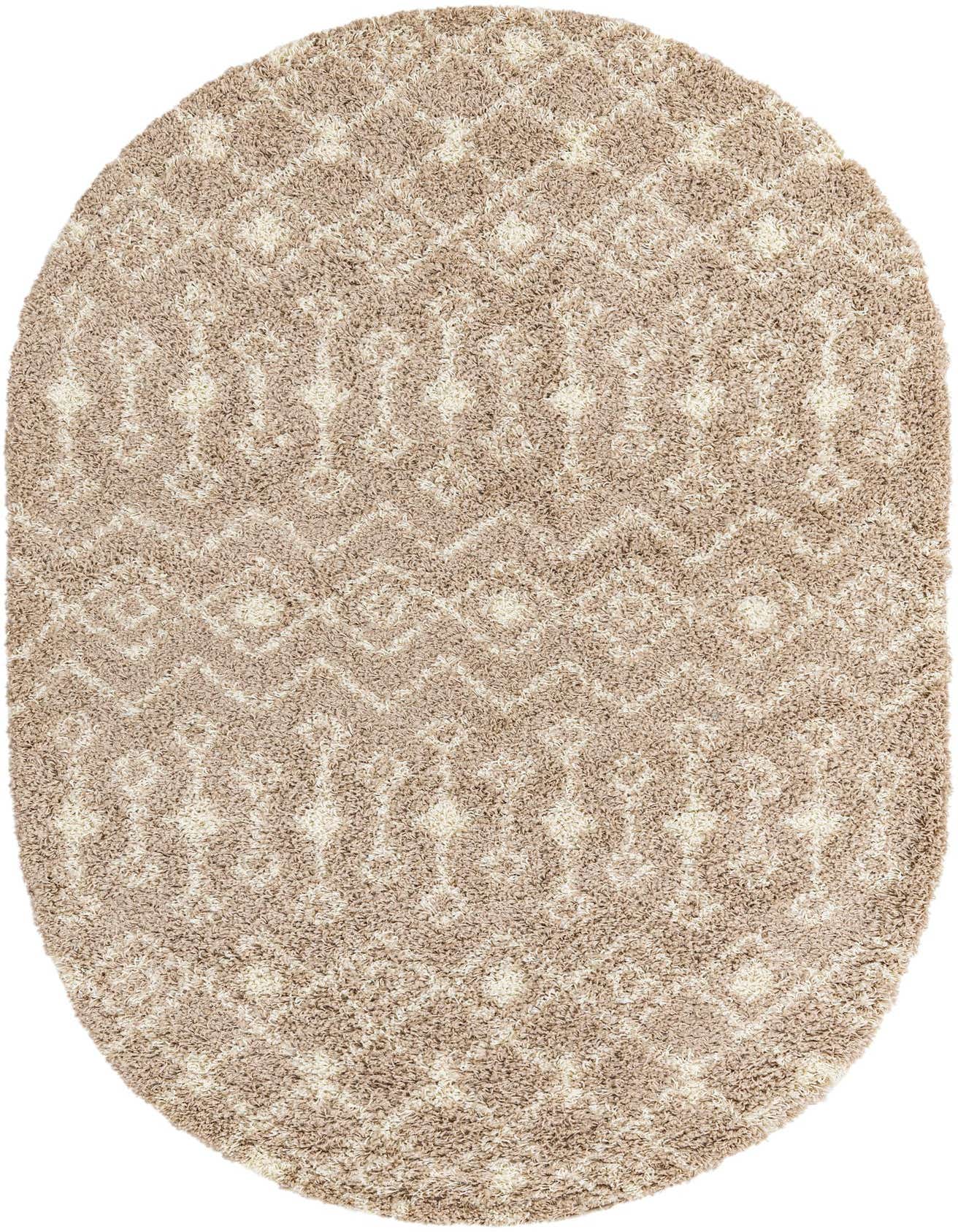 Oval shag rug in varying shades of brown and tan, featuring a tribal geometric pattern, on a white background.