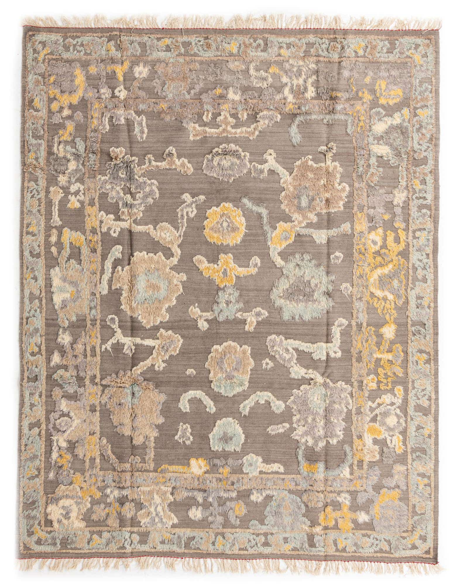 A rectangular 8x10 Darya rug with a high pile, featuring a transitional floral pattern in shades of brown, tan, yellow, and light blue on a dark gray background, with fringed edges.
