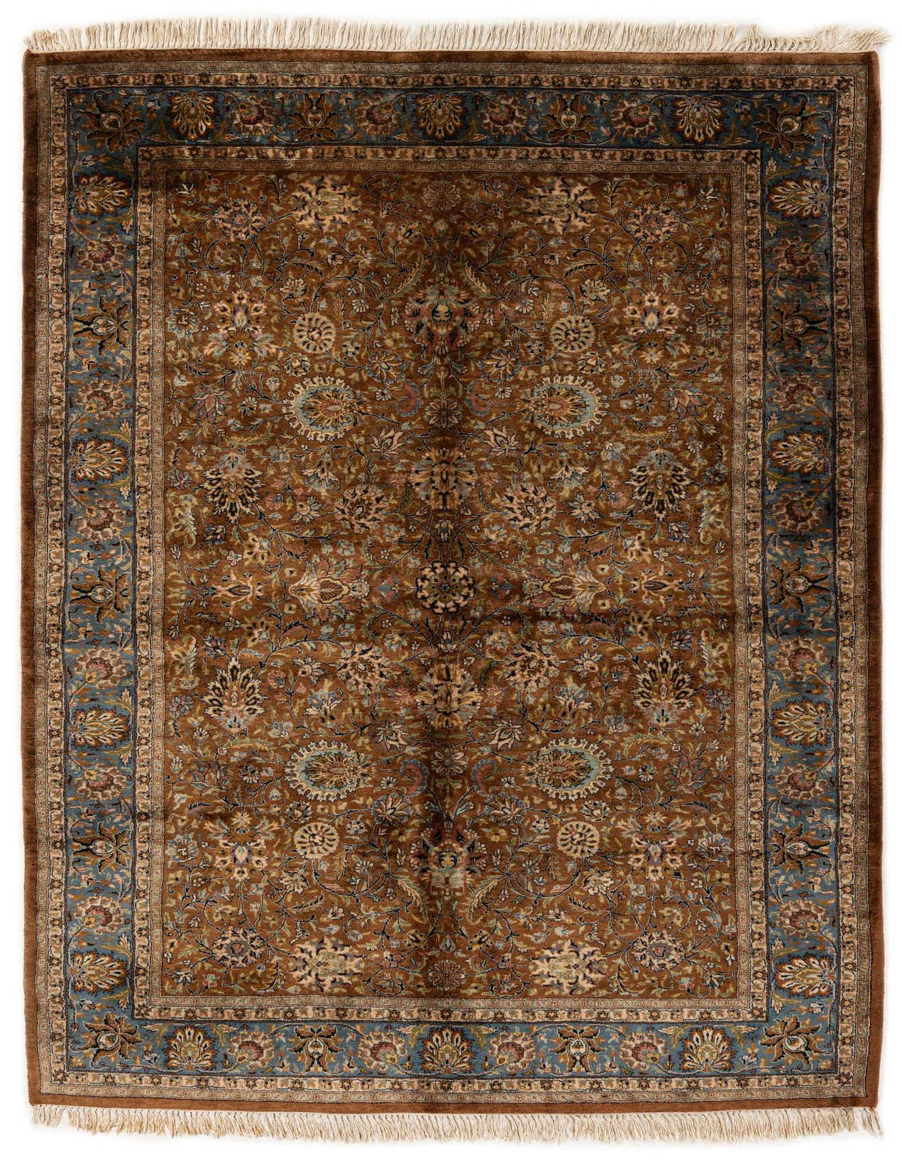 A 5x8 rectangular brown and blue Oriental wool rug with intricate floral patterns and fringe, suitable for a living room.