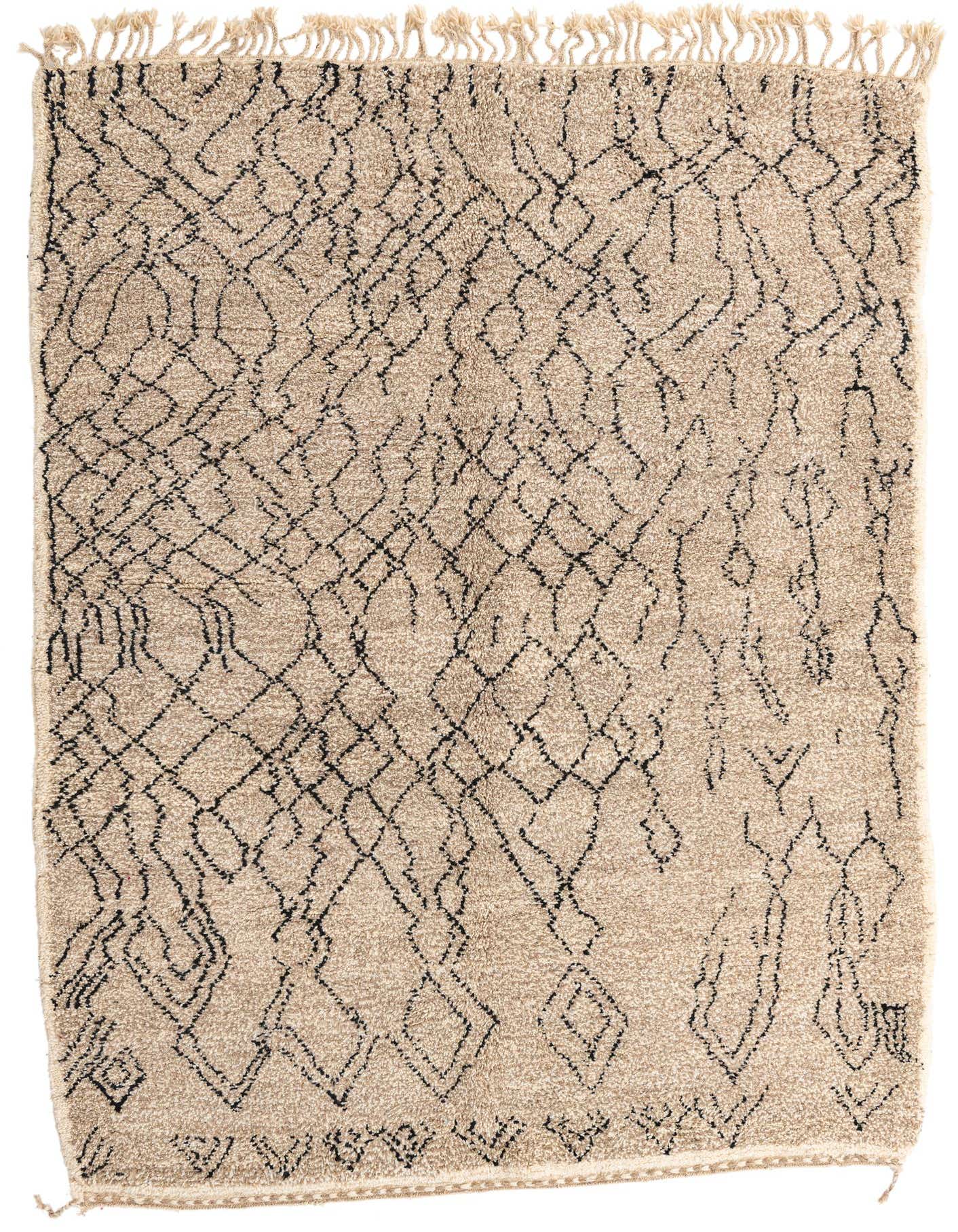 A 7x10 rectangular Moroccan shag rug in tan with a black abstract tribal pattern and fringed ends.