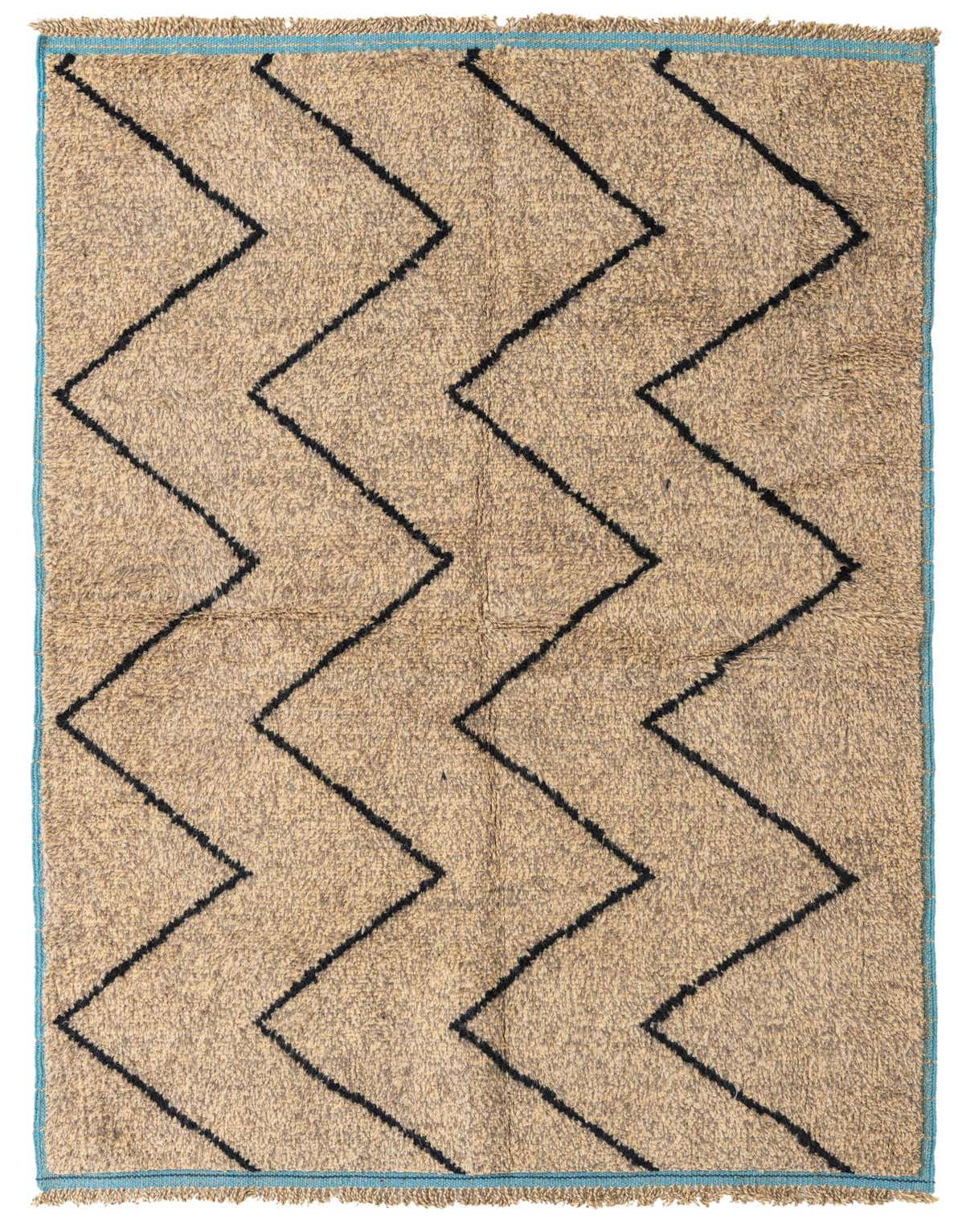 A 5x8 rectangular shag rug with a brown and tan base, featuring bold black zigzag tribal patterns and a thin blue border.