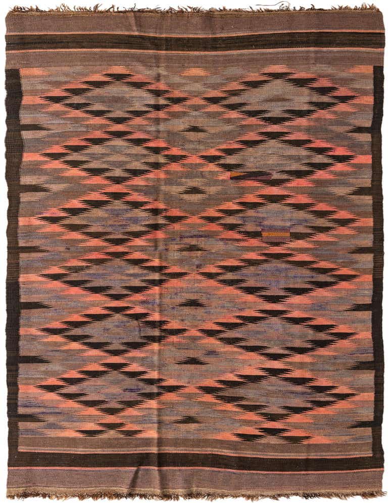 A 11 ft runner Kilim Fars rug with tribal geometric patterns in shades of brown, tan, and faded coral, featuring a flatweave texture and fringe.