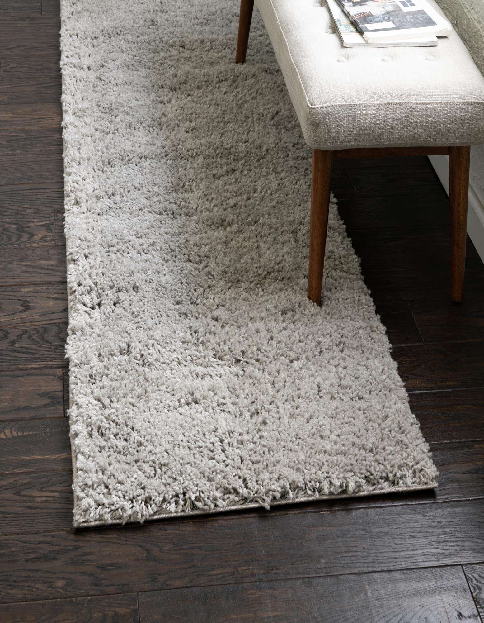 A long, rectangular 13 ft runner rug in a solid gray color with a soft, textured shag pile, perfect for a hallway.