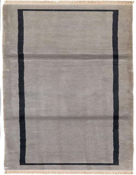 A handmade 11 ft gray wool runner rug with a dark gray modern border, ideal for a hallway.