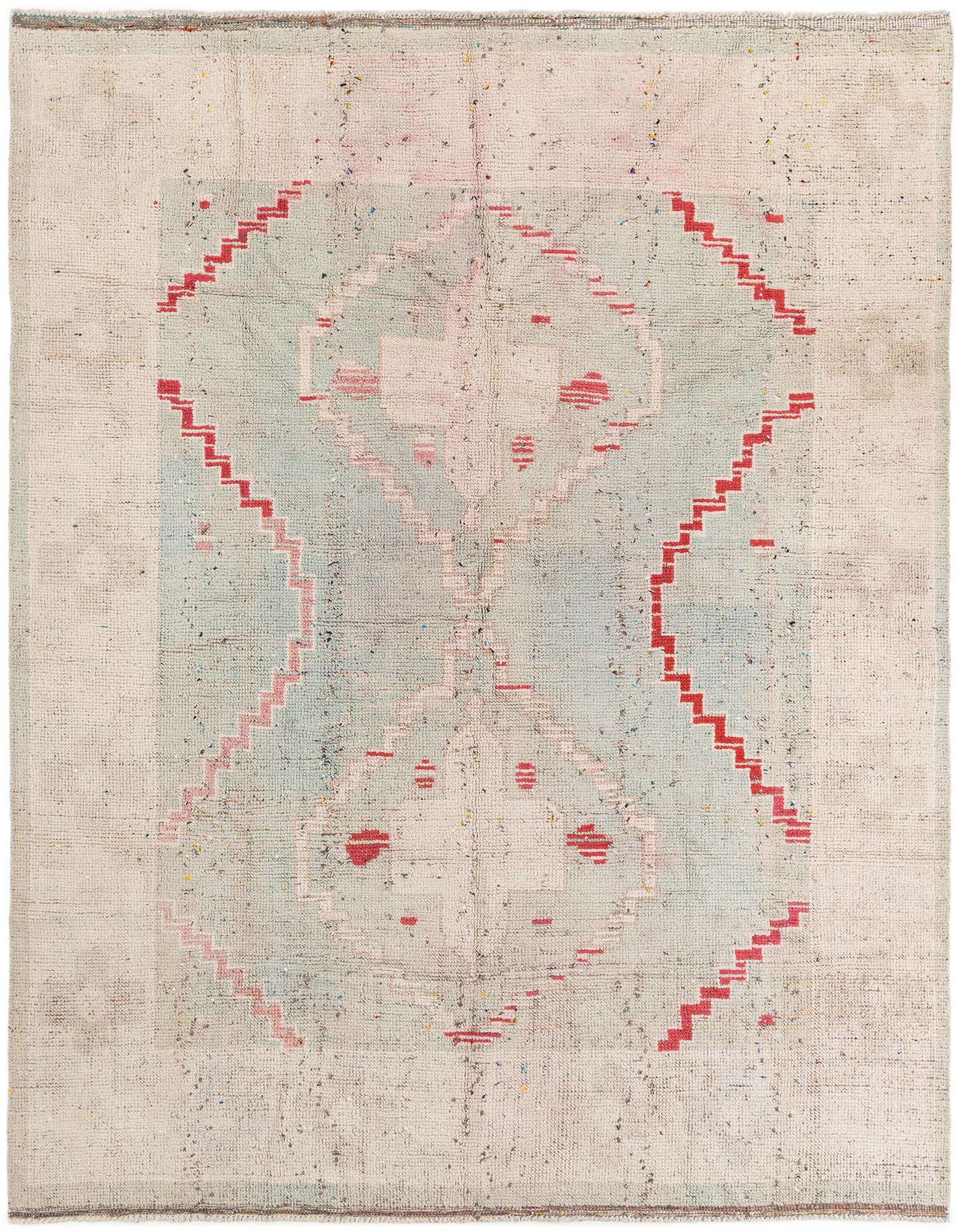 An 8x10 rectangular Moroccan shag rug with a central green and pink medallion pattern, bordered by red tribal zigzags on a cream background.