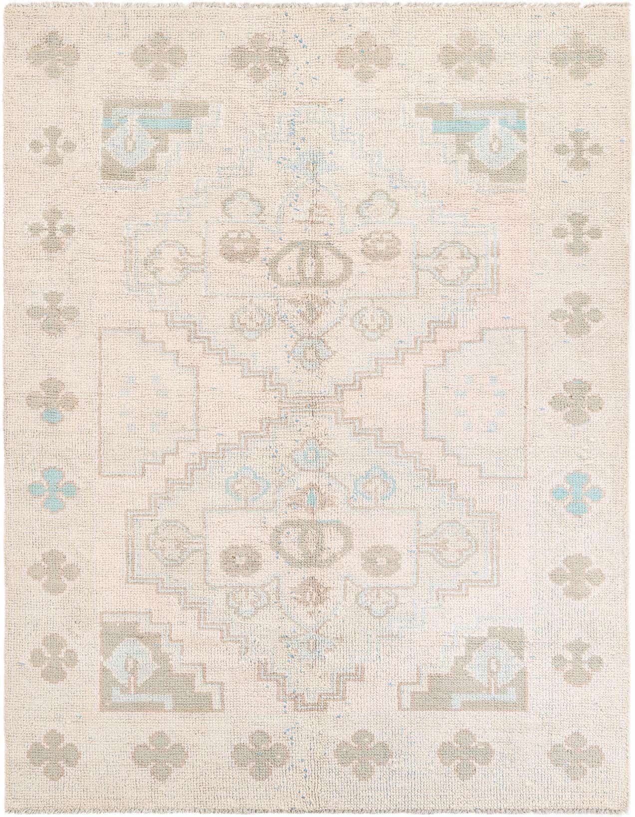A 6x9 rectangular pink shag rug with a faded tribal medallion pattern in light blue and grey.