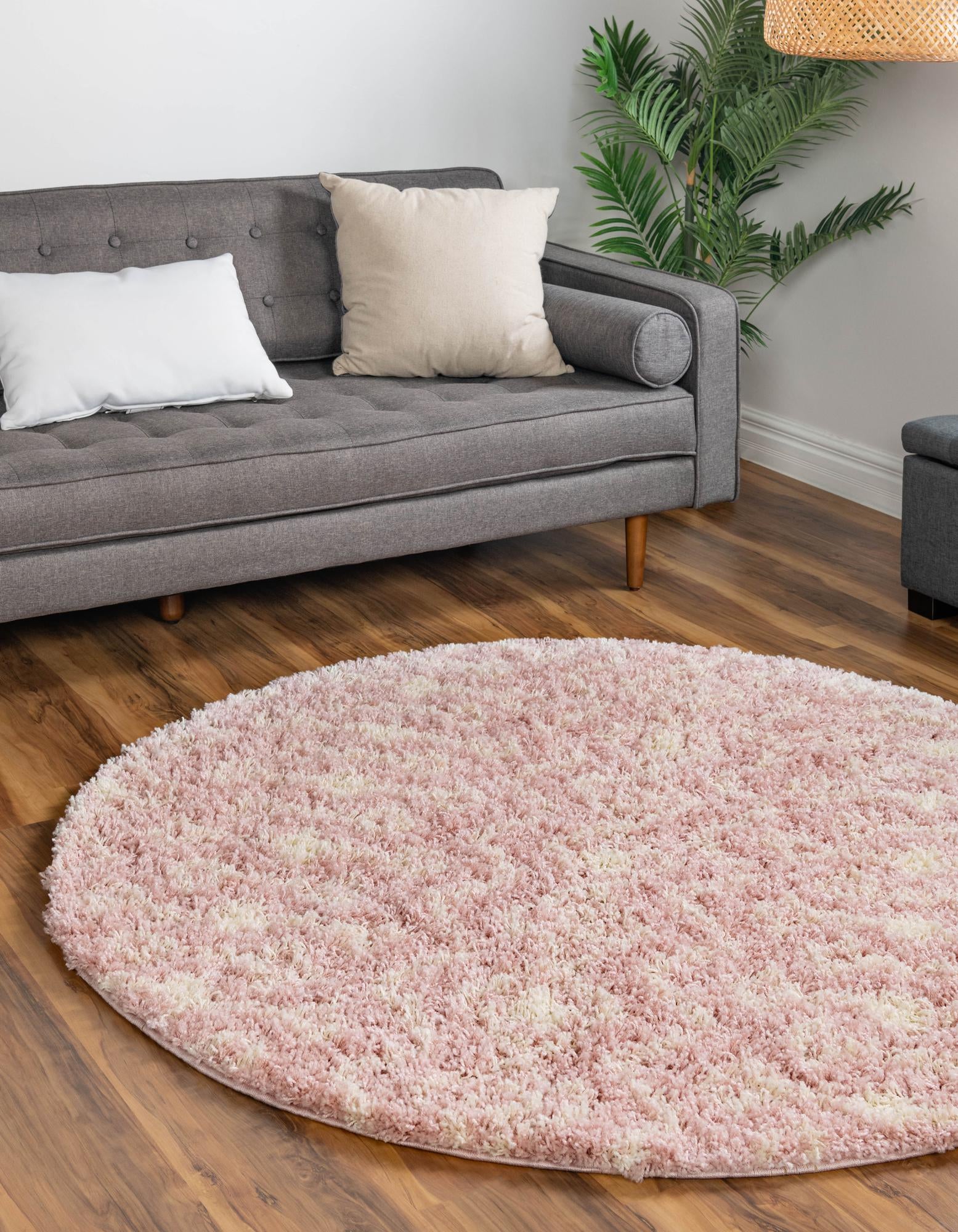 A round 10' pink shag rug with a cream tribal geometric pattern, featuring a soft, textured pile.