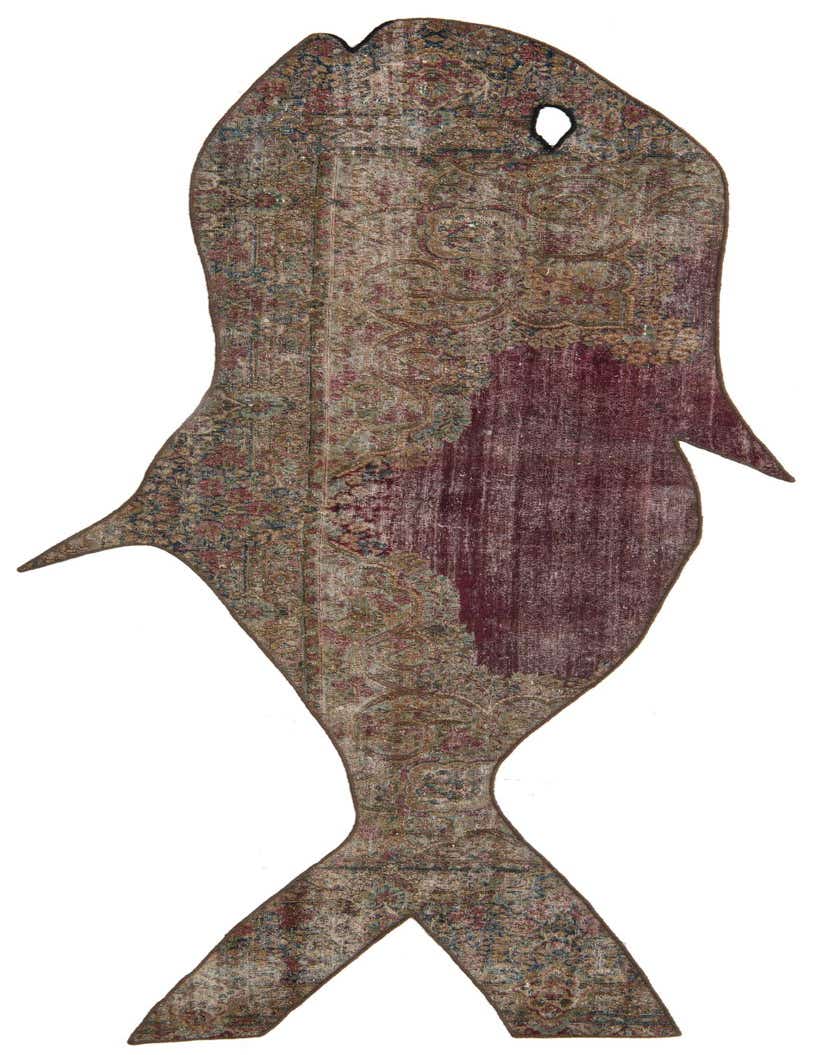 A unique fish-shaped runner rug with a distressed Persian pattern in shades of pink, red, and muted earth tones.