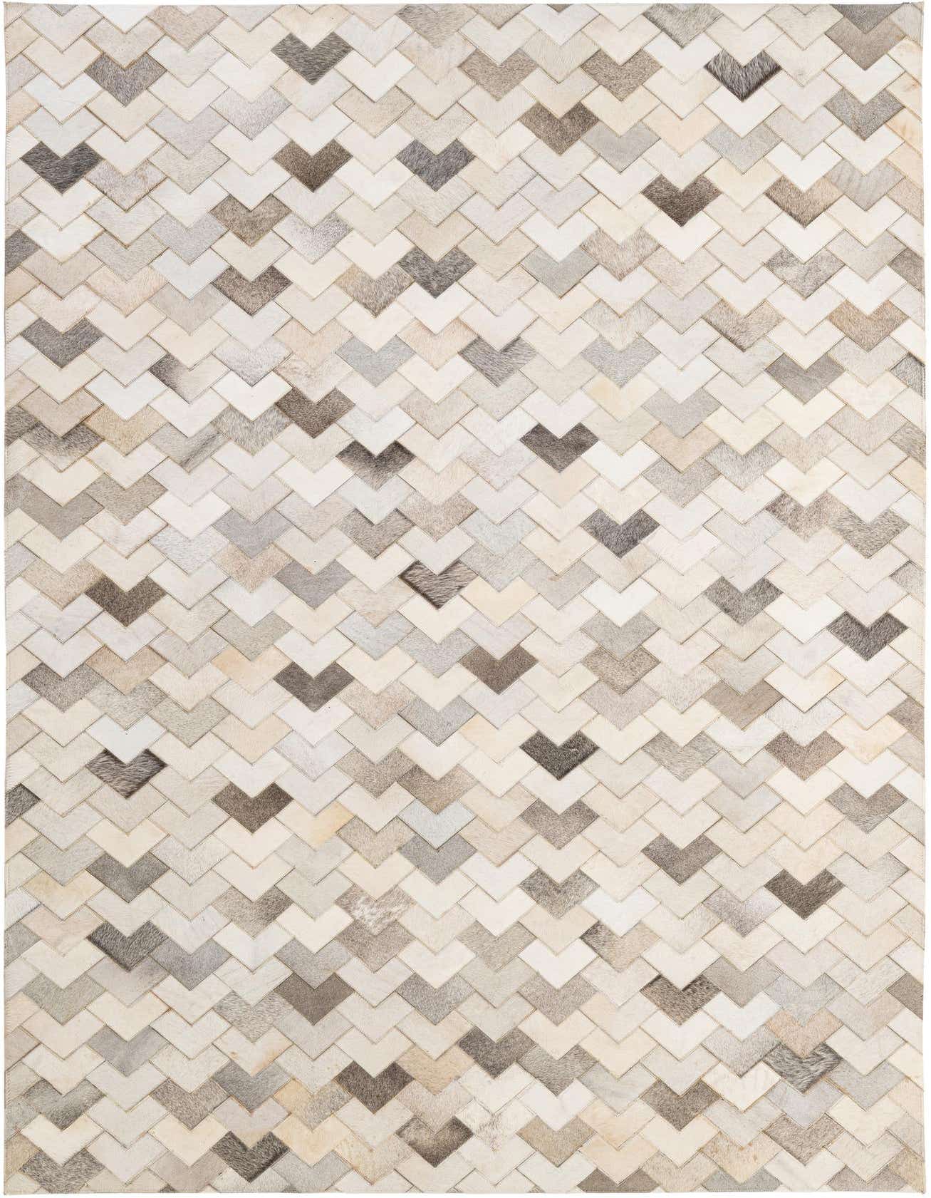 A 5x8 rectangular cowhide patchwork rug featuring a modern chevron pattern in various shades of cream, beige, and gray.