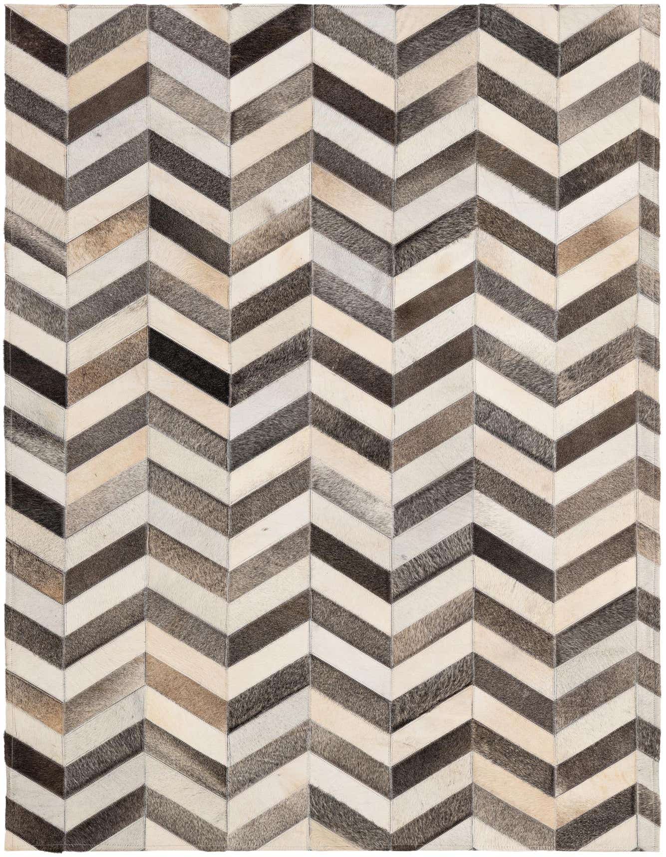 A rectangular 4x6 patchwork cowhide rug featuring a modern chevron pattern in various shades of brown, black, and white.