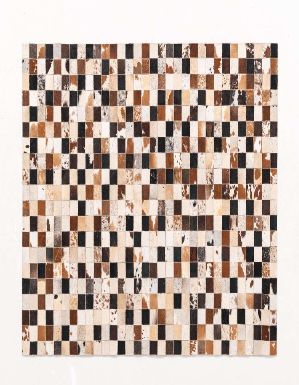 A 5x8 rectangular Cowhide rug featuring a modern checkered pattern in multi-colored natural cowhide and leather squares.