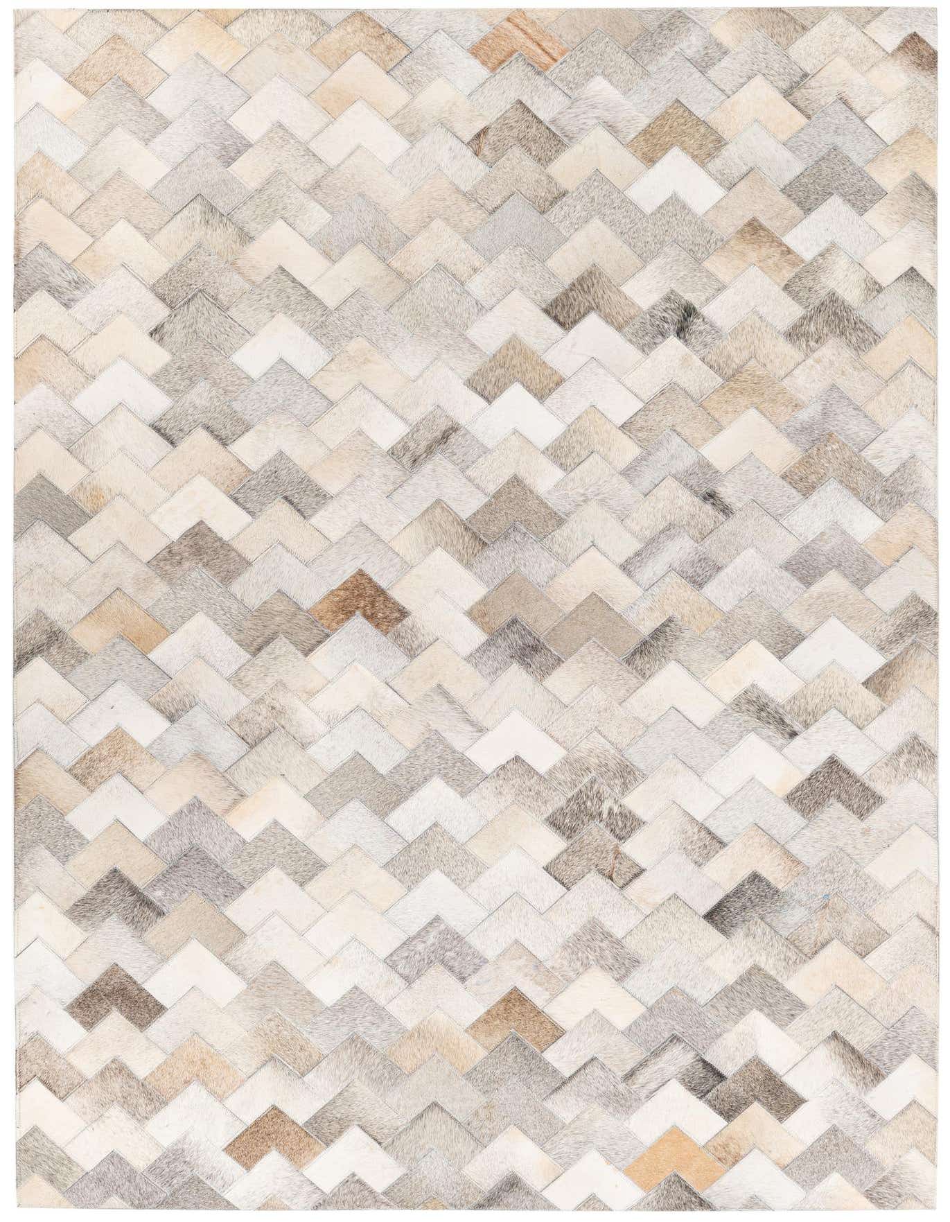 A rectangular 4x6 modern rug featuring a chevron pattern made from multi-colored cowhide and leather patches in shades of beige, brown, and gray.