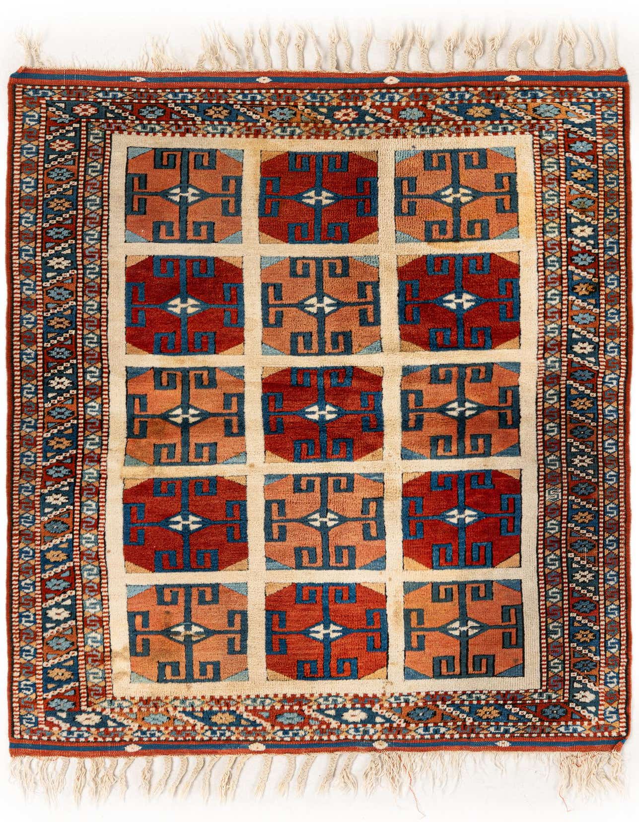 A 3x5 multi-colored rectangular Heriz Oriental wool rug featuring a grid of red and orange geometric patterns with blue and white accents, surrounded by intricate borders and fringe.