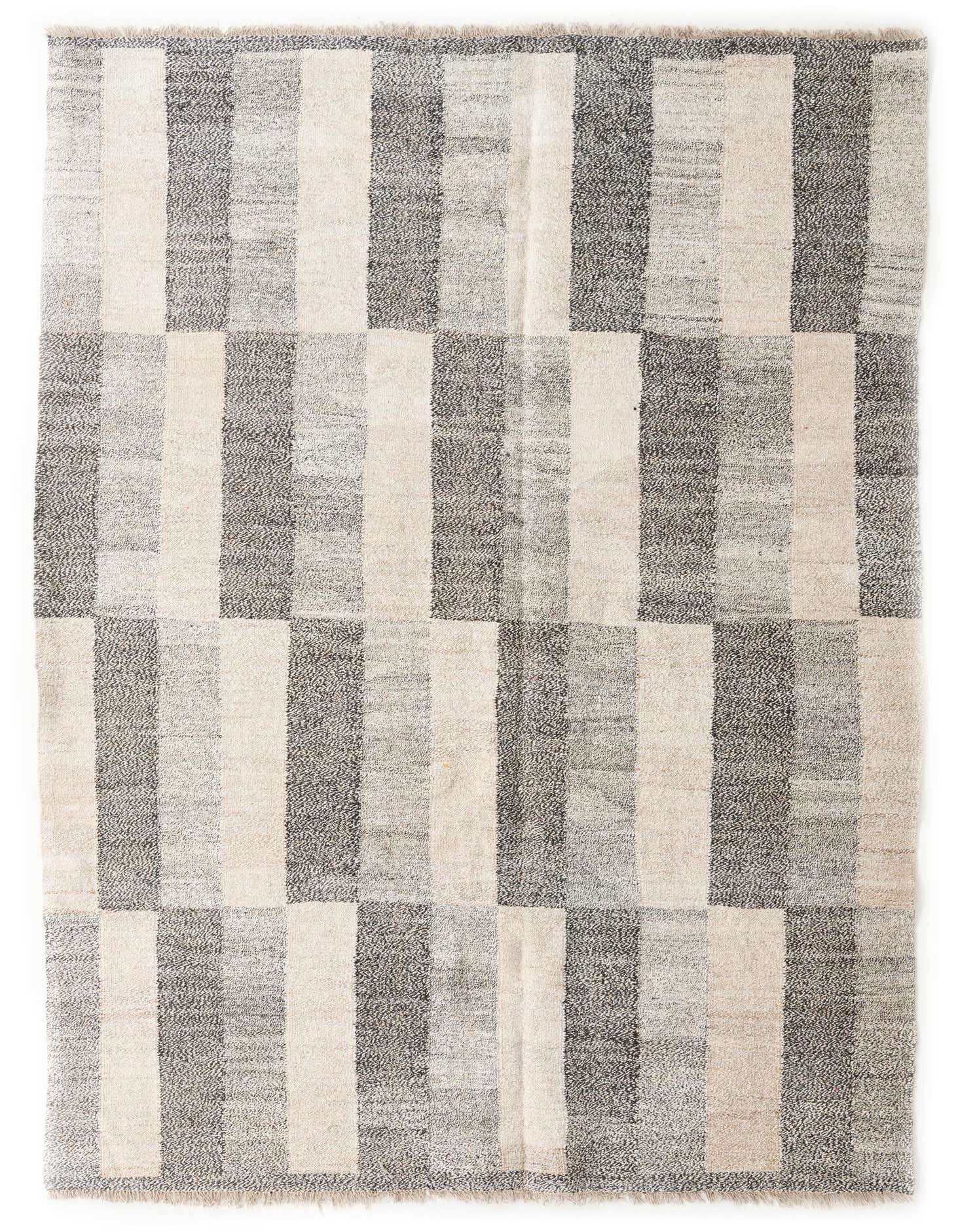 A 7x10 rectangular Kilim Modern rug with a multi-colored tribal pattern of alternating light and dark vertical stripes.
