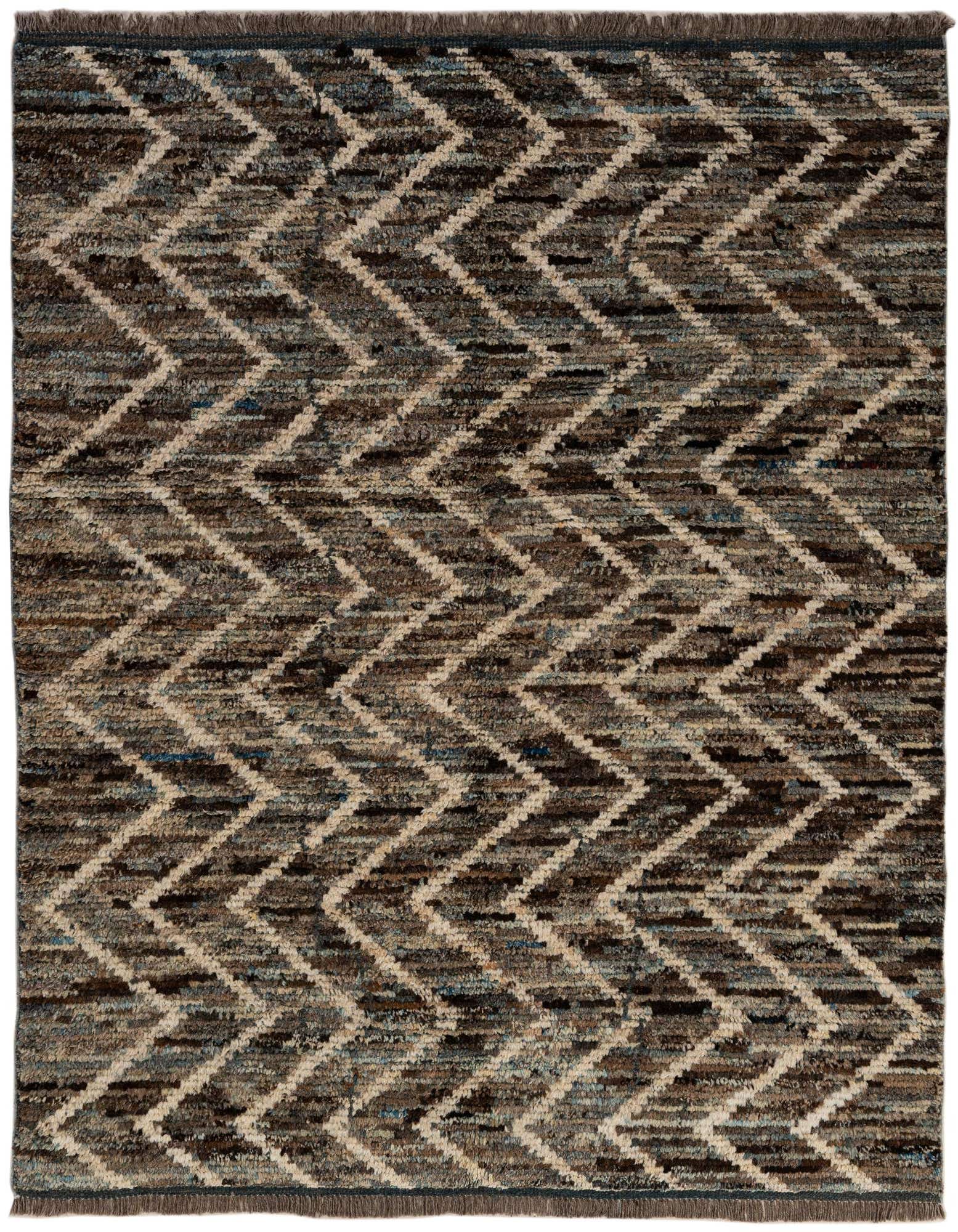 A 5x7 rectangular multi-colored wool rug featuring a modern tribal zigzag pattern in varying shades of brown, beige, and blue.