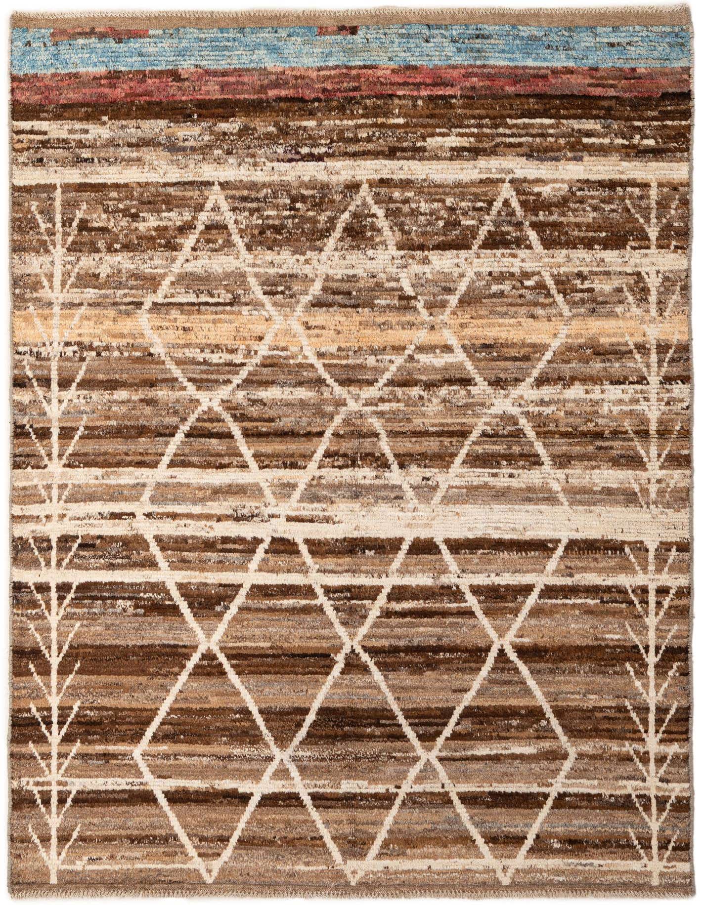 A 5x8 rectangular wool rug with a multi-colored striped background in browns and creams, featuring a white tribal geometric pattern and light blue and red bands at the top.
