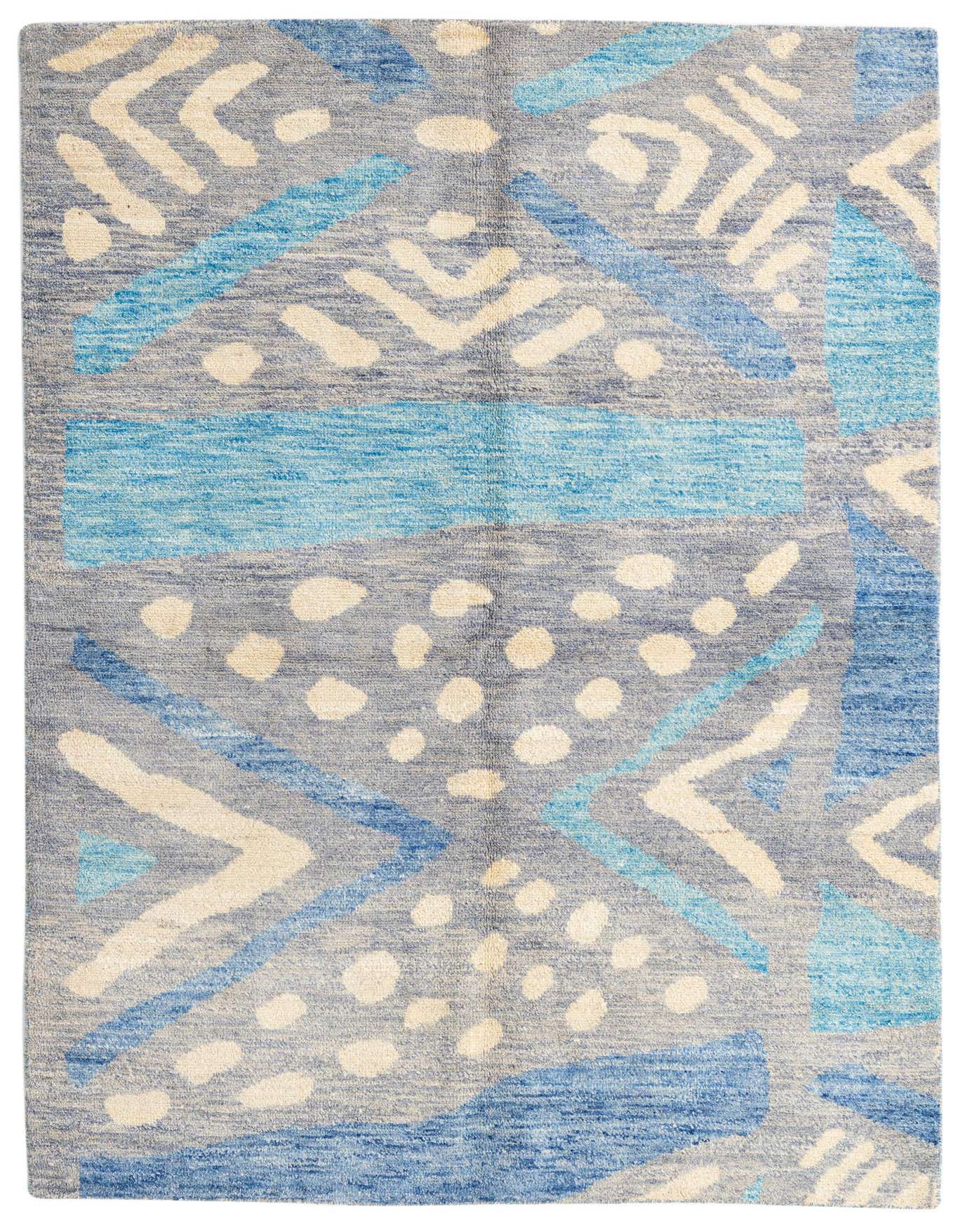 A 6x9 rectangular multi-colored wool shag rug featuring a modern tribal and abstract pattern in shades of blue, cream, and gray.
