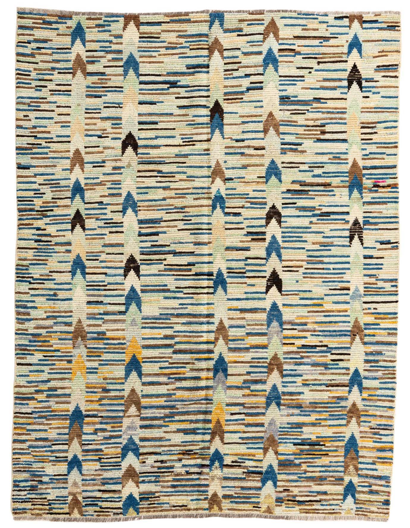 A 6x9 rectangular multi-colored shag rug with a tribal arrow pattern in blues, browns, and yellows, perfect for a living room.
