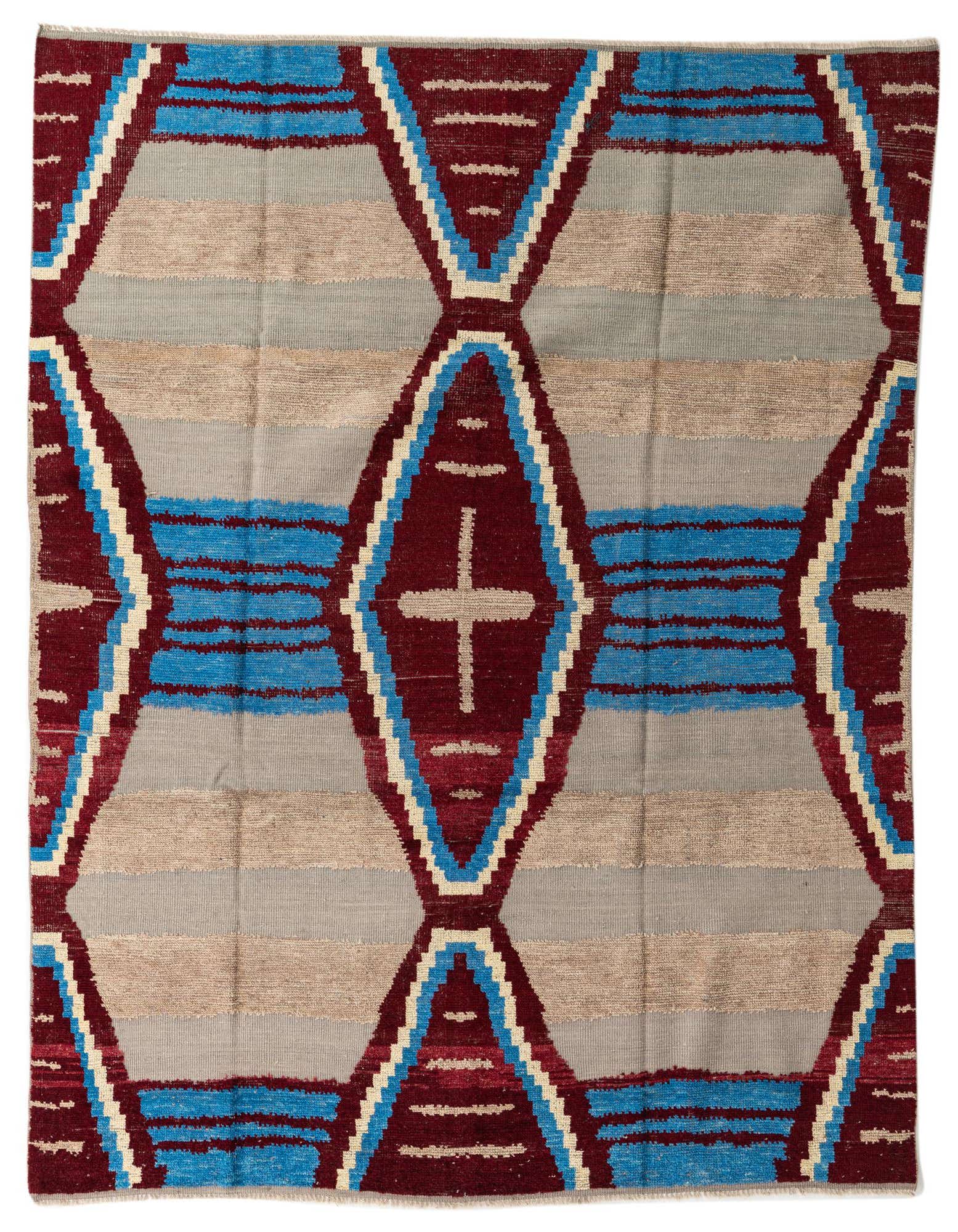 A multi-colored 8x10 rectangular wool shag rug featuring a bold tribal and abstract pattern in maroon, blue, beige, and gray.