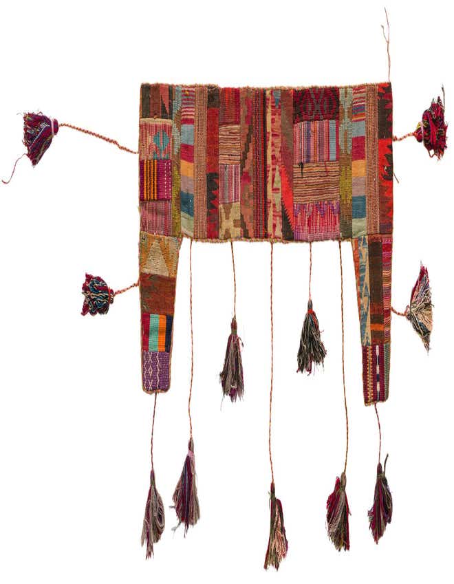 A vibrant, multi-colored abstract wool wall hanging with a rectangular shape and decorative tassels.