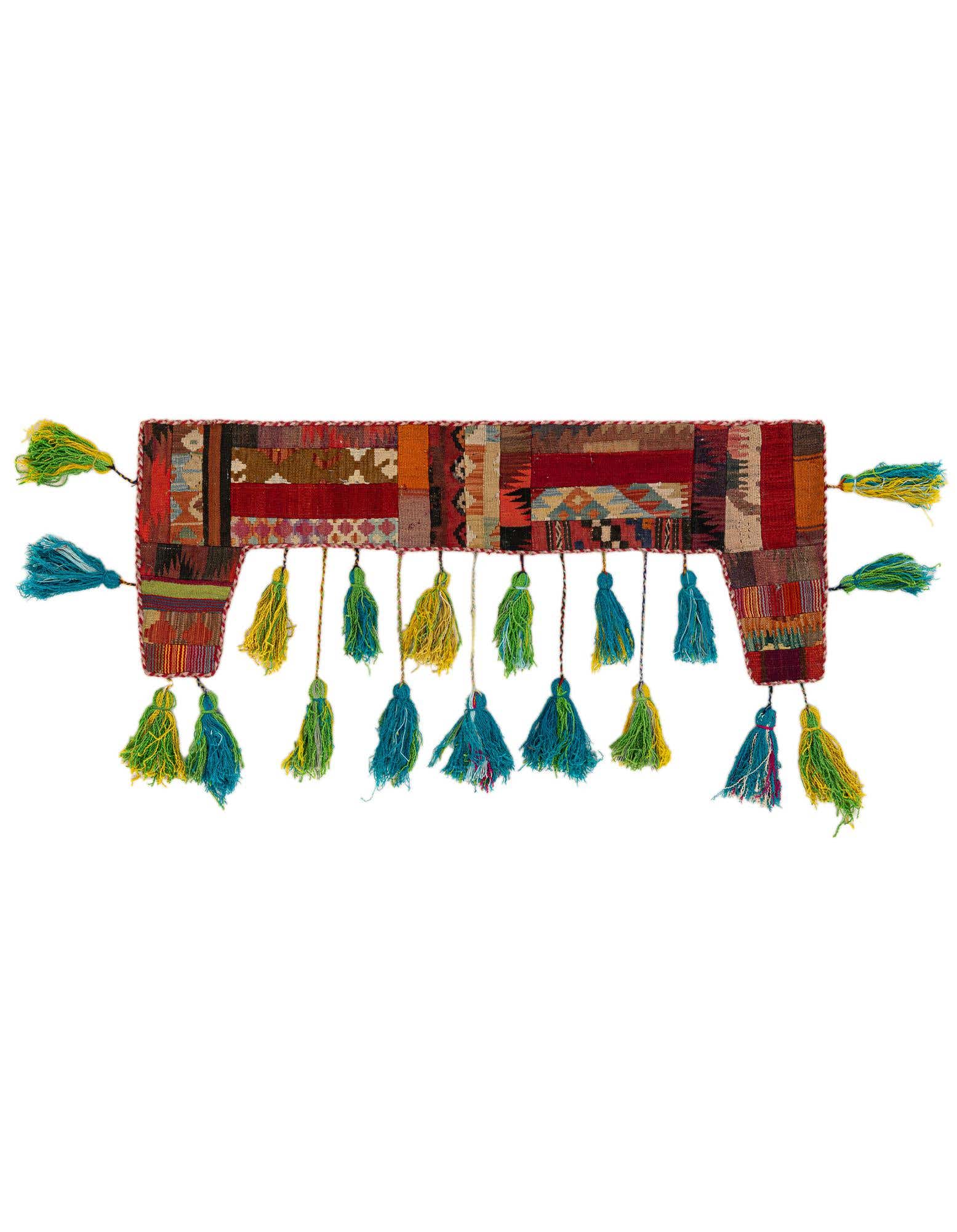 A vibrant, multi-colored rectangular wall art piece with abstract patterns and numerous green and blue tassels hanging from the bottom.