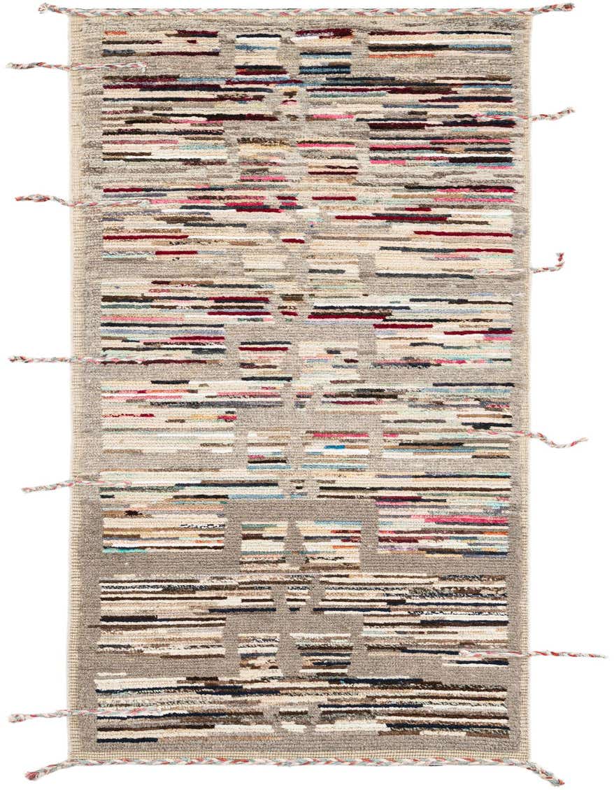 A handmade 8 ft runner rug with a multi-colored tribal pattern over a light gray base, featuring shag pile.
