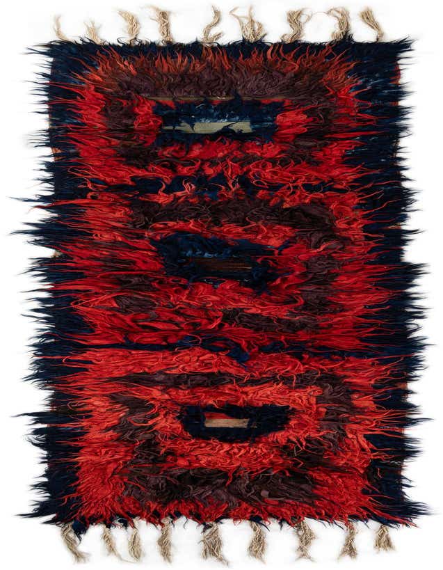 A vibrant 12 ft runner rug with a shag pile, featuring bold red, navy, and brown tribal patterns, perfect for a hallway.