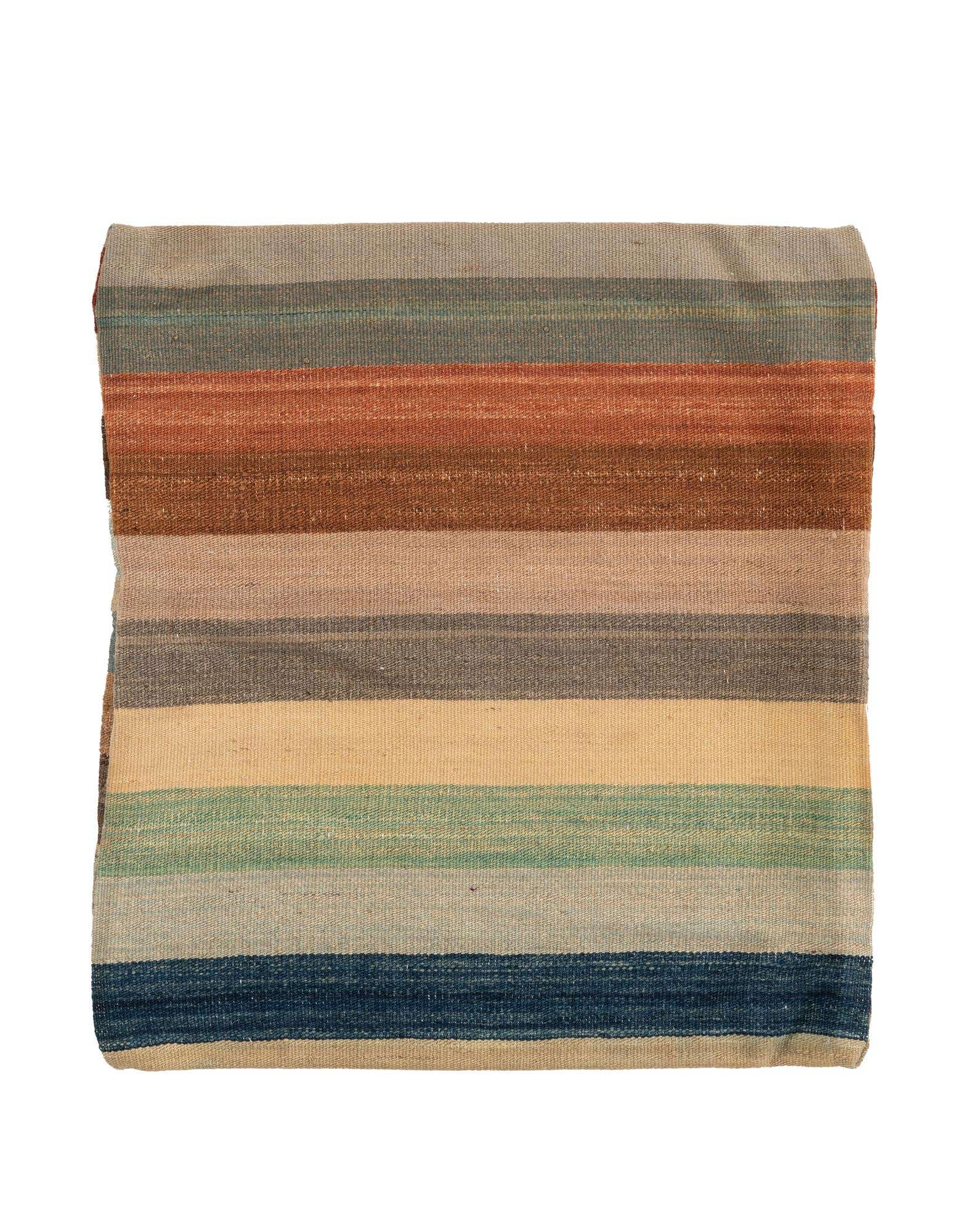 A square, multi-colored wool rug with horizontal stripes in earthy tones, folded and displayed on a white background.
