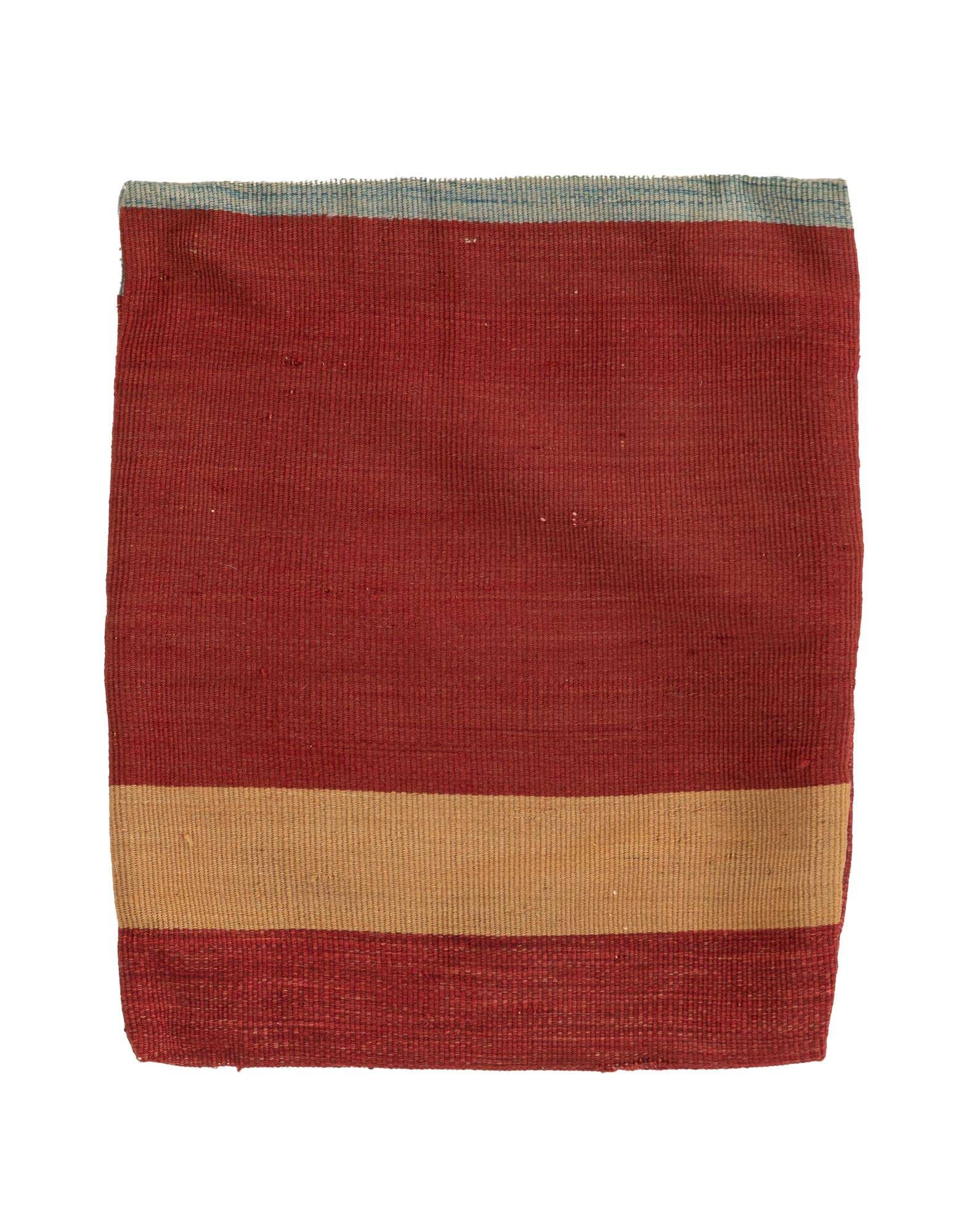 A square, multi-colored wool rug featuring a wide red field, a central tan stripe, and a thin blue stripe at the top.