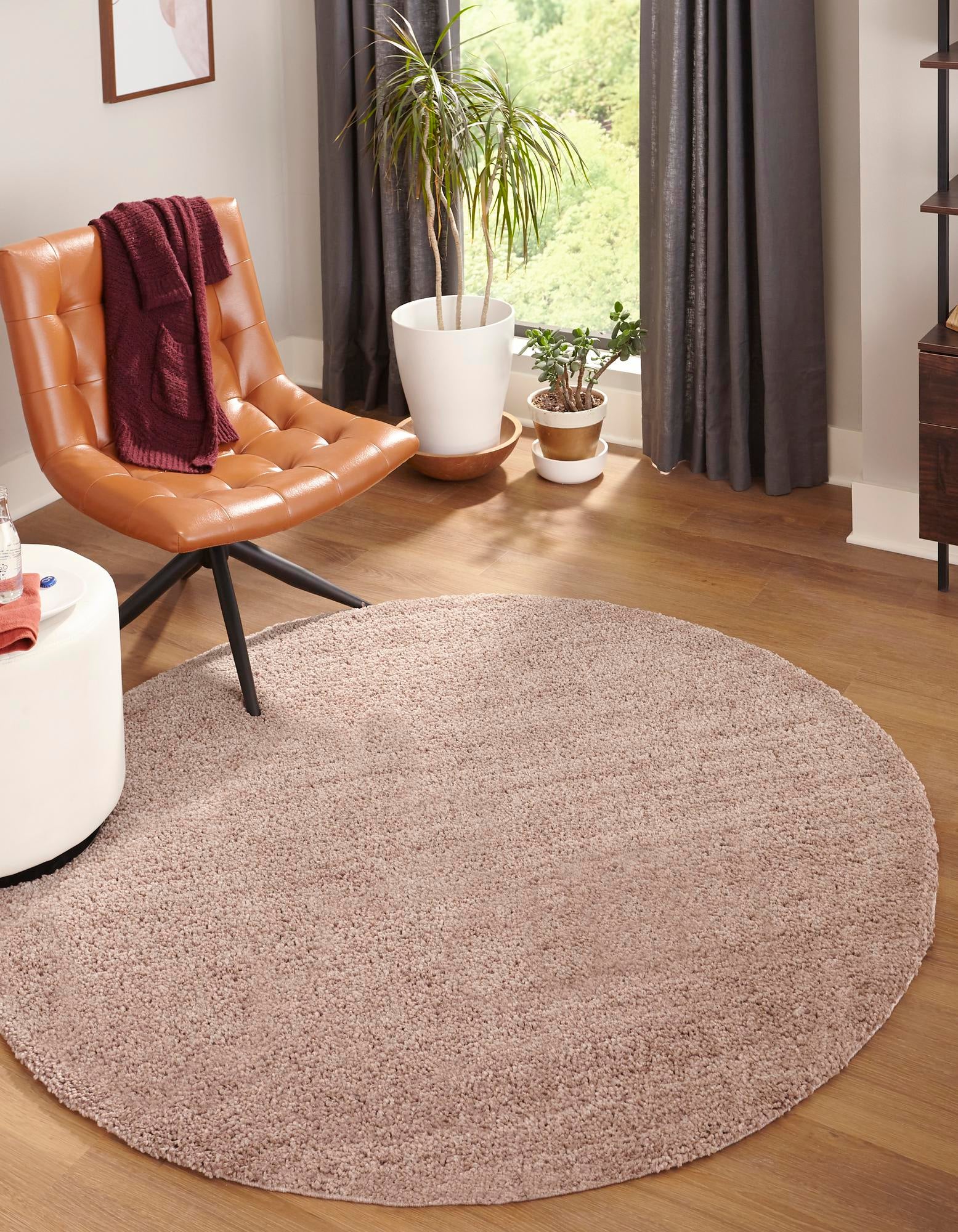 A 3' 3 x 3' 3 round Jill Zarin Shaggy Chic rug in a solid brown/tan color, featuring a soft, textured shag pile.
