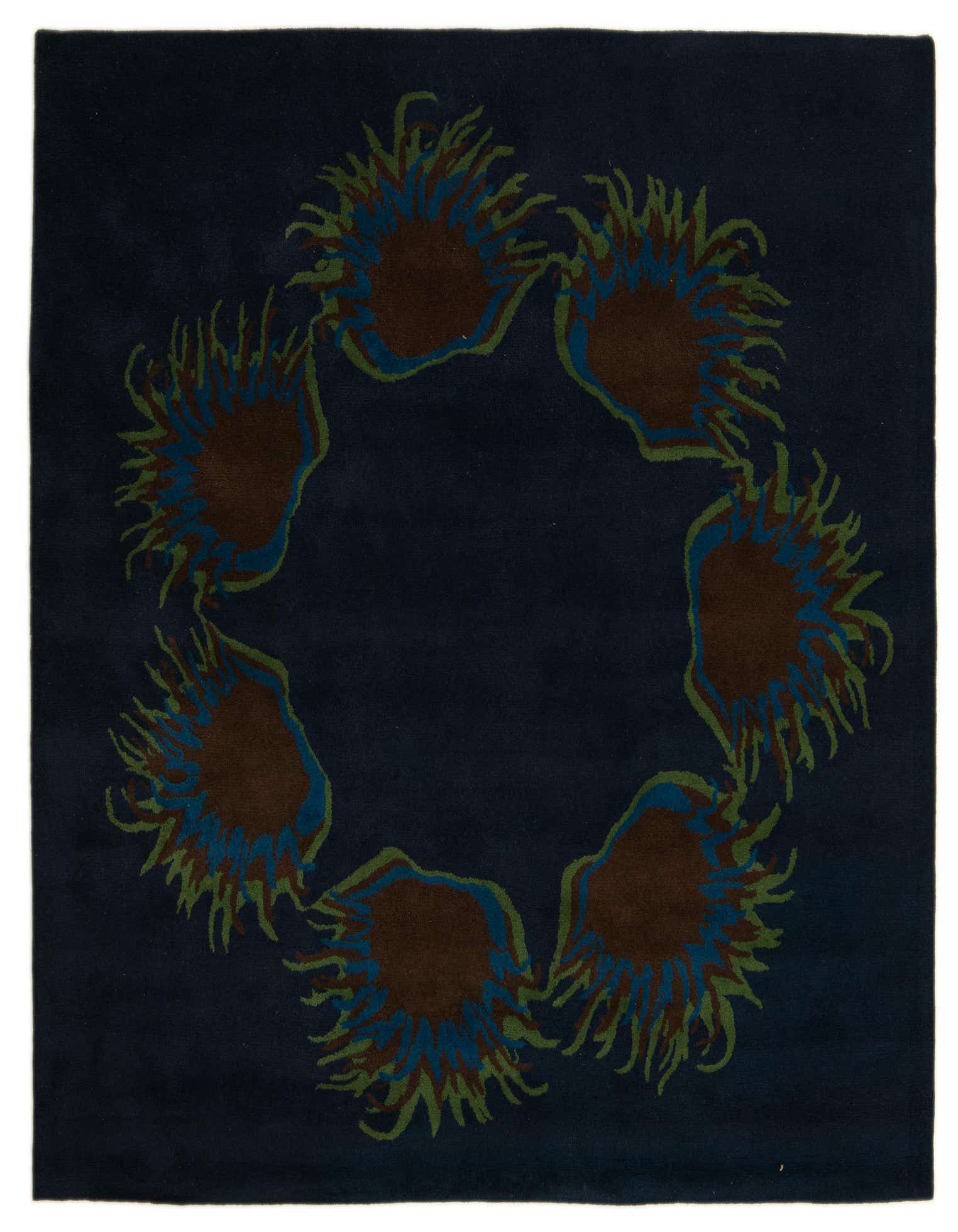 A dark blue square rug with a circular modern floral pattern featuring brown, blue, and green spiky shapes.