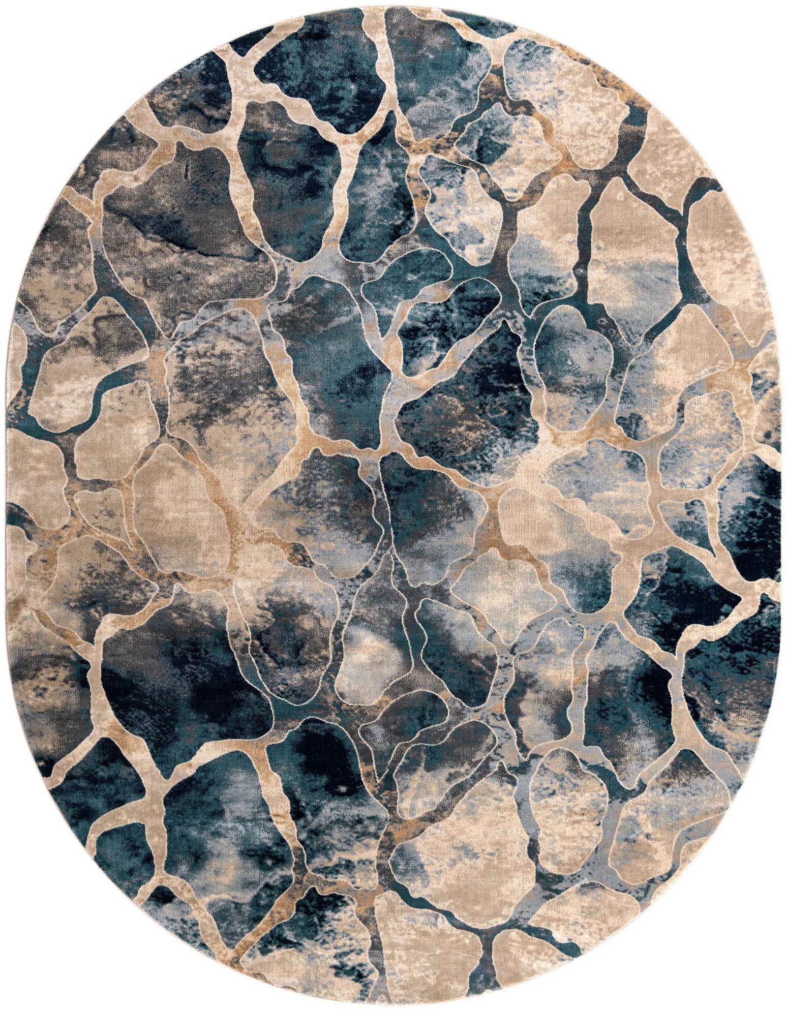 An oval modern abstract rug featuring a mosaic-like pattern of varying blue and beige tones with thin gold lines.