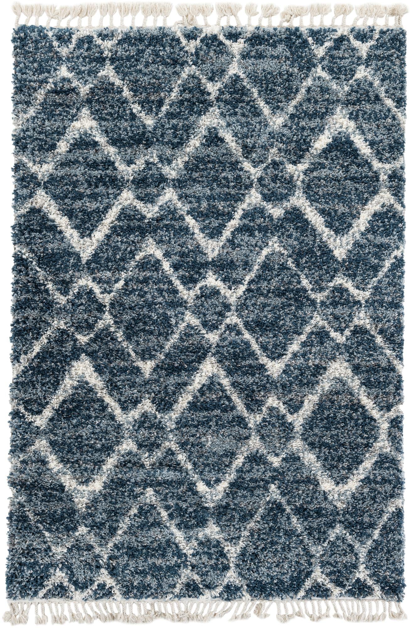 A rectangular 5x8 Athena Shag rug in varying shades of blue with a modern geometric diamond pattern in white, featuring white tassels on the ends.