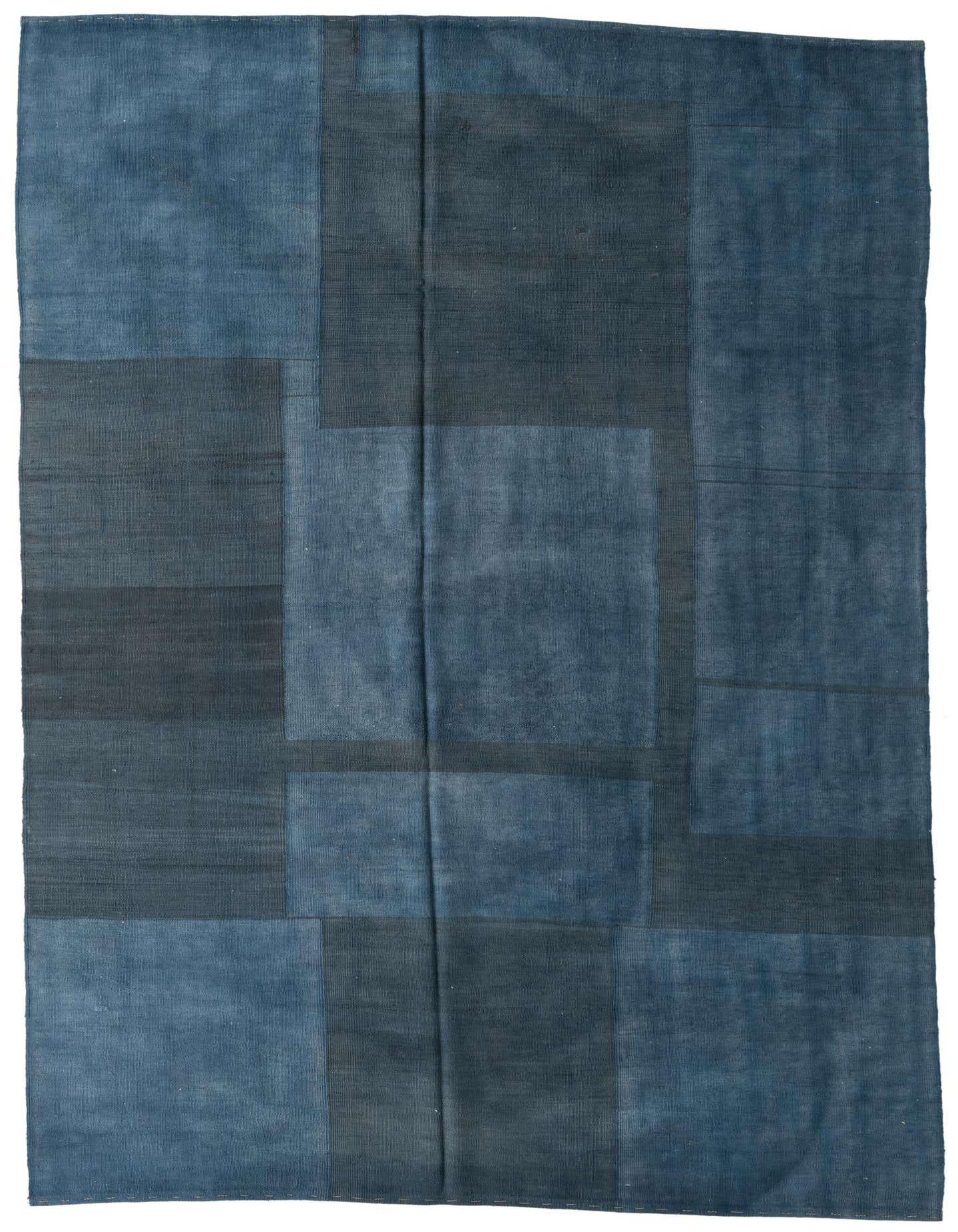 A 7x10 rectangular flatweave rug featuring a modern abstract design with various shades of blue and navy blocks.